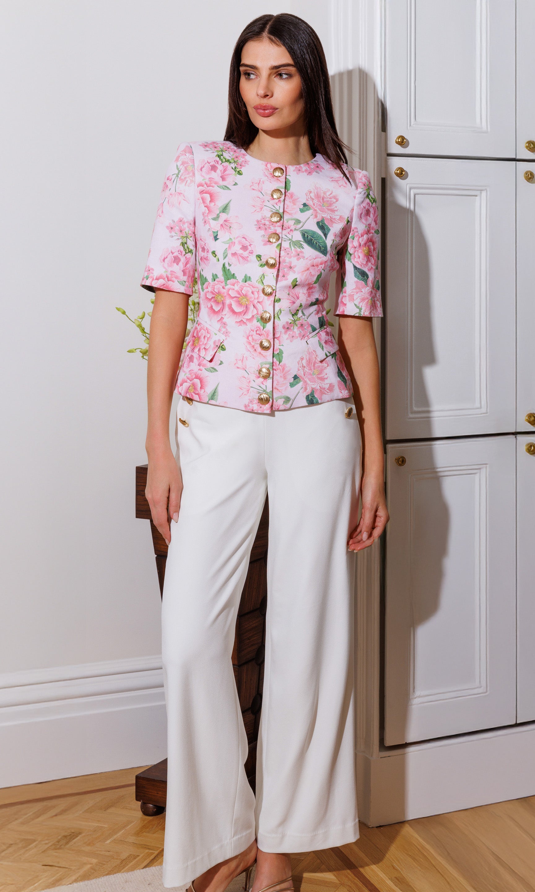 Model wears the Adriana Floral Linen Jacket in pink petal dream in a full-body view, featuring the polished floral look, button-front detail, and refined linen tailoring.