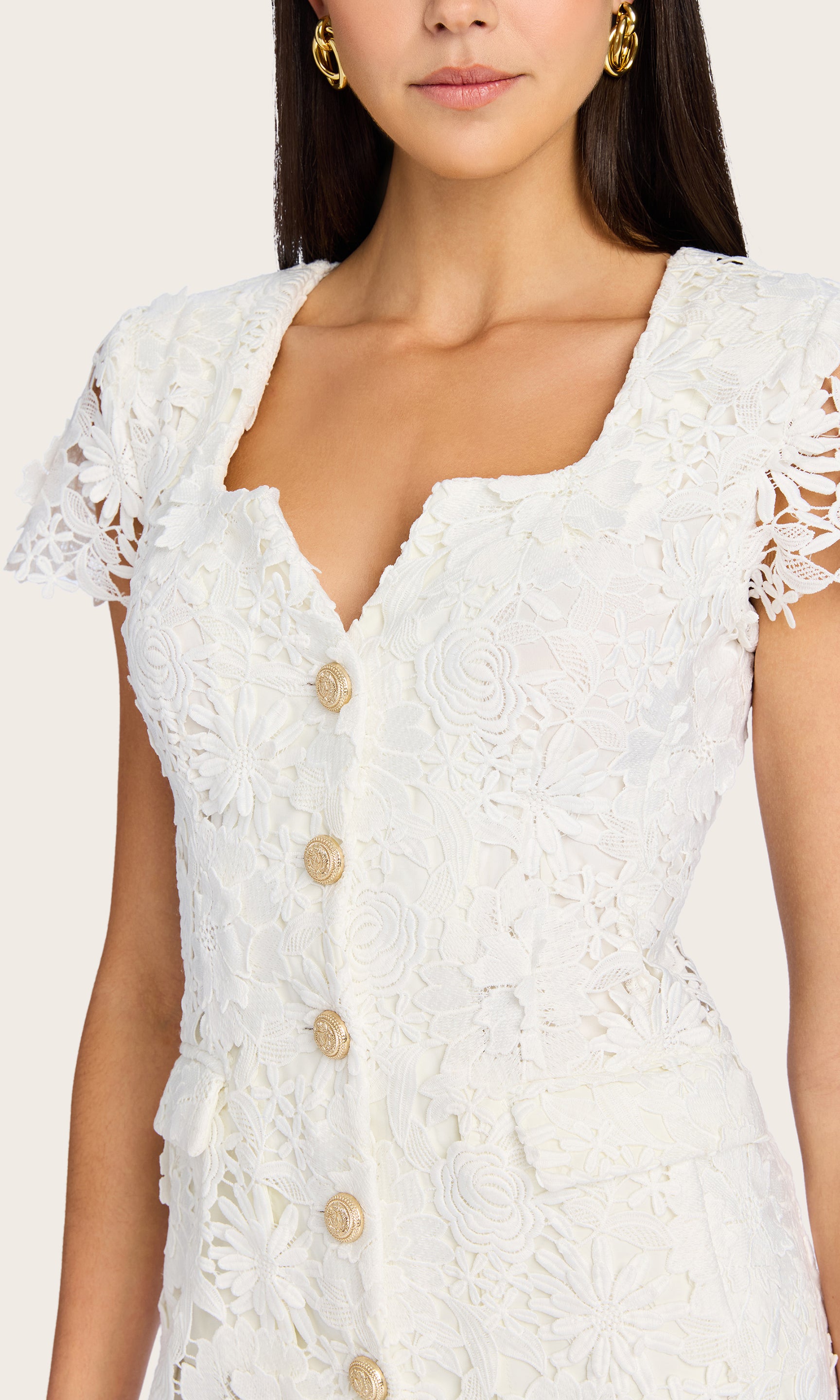 Close-up front view of the model in the Brunella 3D Lace Dress, highlighting the V-notch neckline and lace texture.