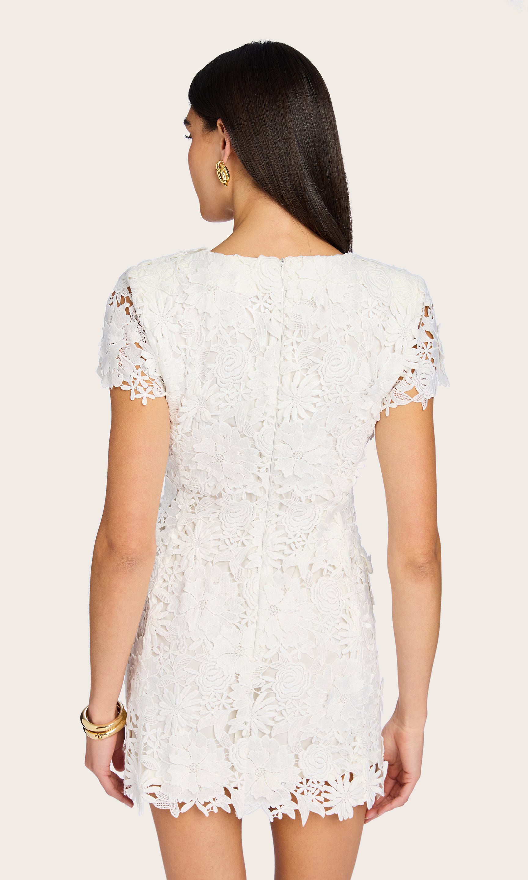 Another rear view of the model wearing the Brunella 3D Lace Dress, emphasizing the scalloped lace hem and back structure.