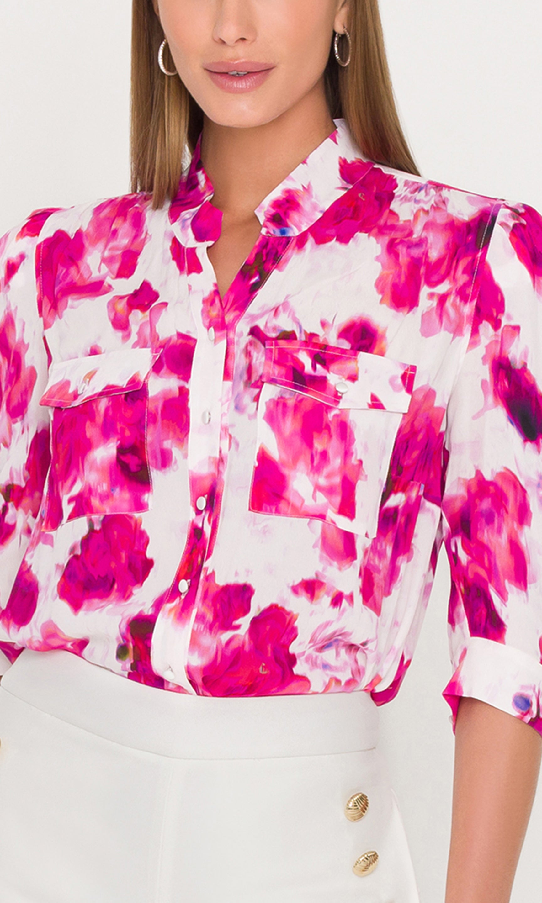 Close-up of woman wearing a colorful floral blouse with a white background