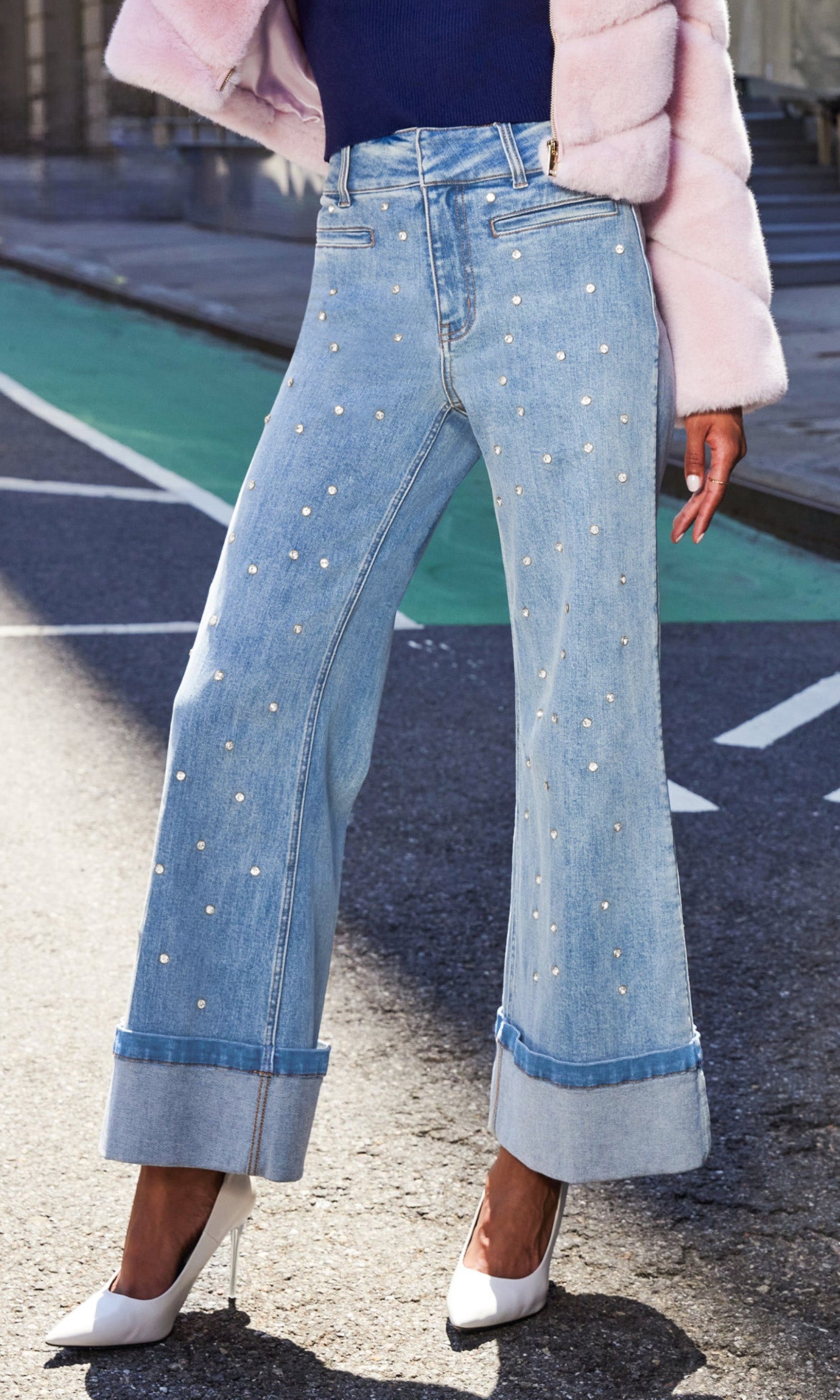 Model walking in the Raquel Crystal Stud Jeans with a navy top, captured in a candid street-style side view.