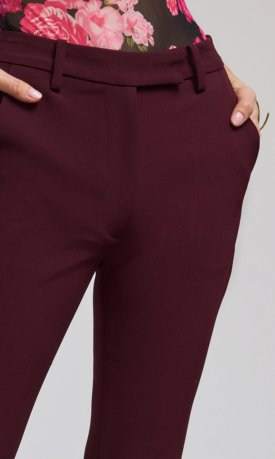 The image features a woman in chic burgundy Malbec crepe pants, highlighting her fashionable attire.