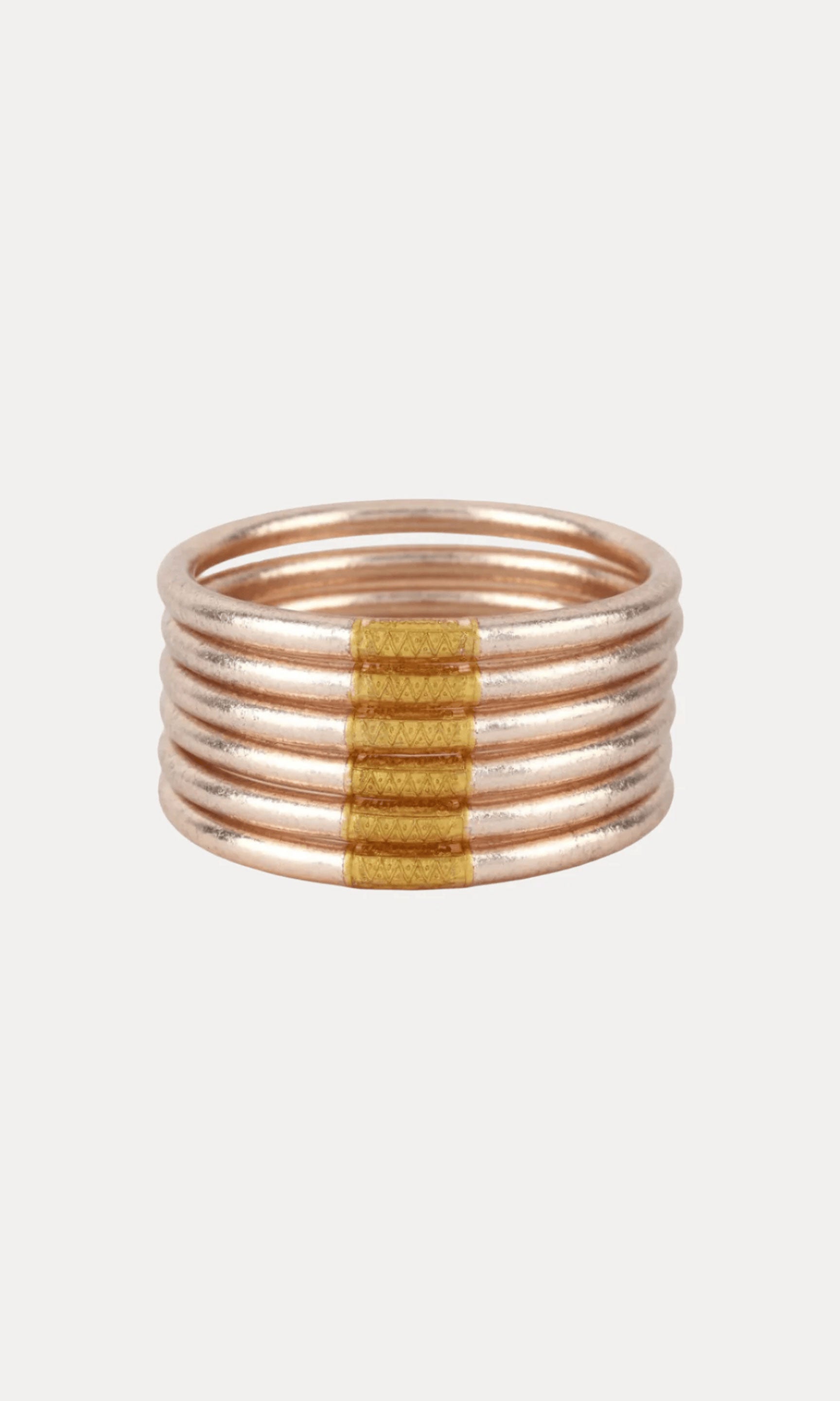 A multi-band ring featuring five thin rose gold bands stacked together with a central band of textured gold.
