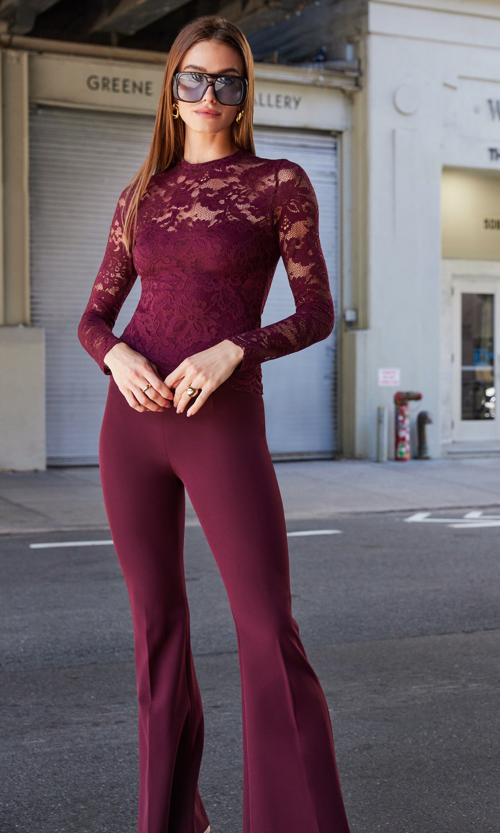 Street-style front view of the Wesley Crepe Pants in burgundy, paired with a matching long-sleeve lace top for an elegant monochrome look.