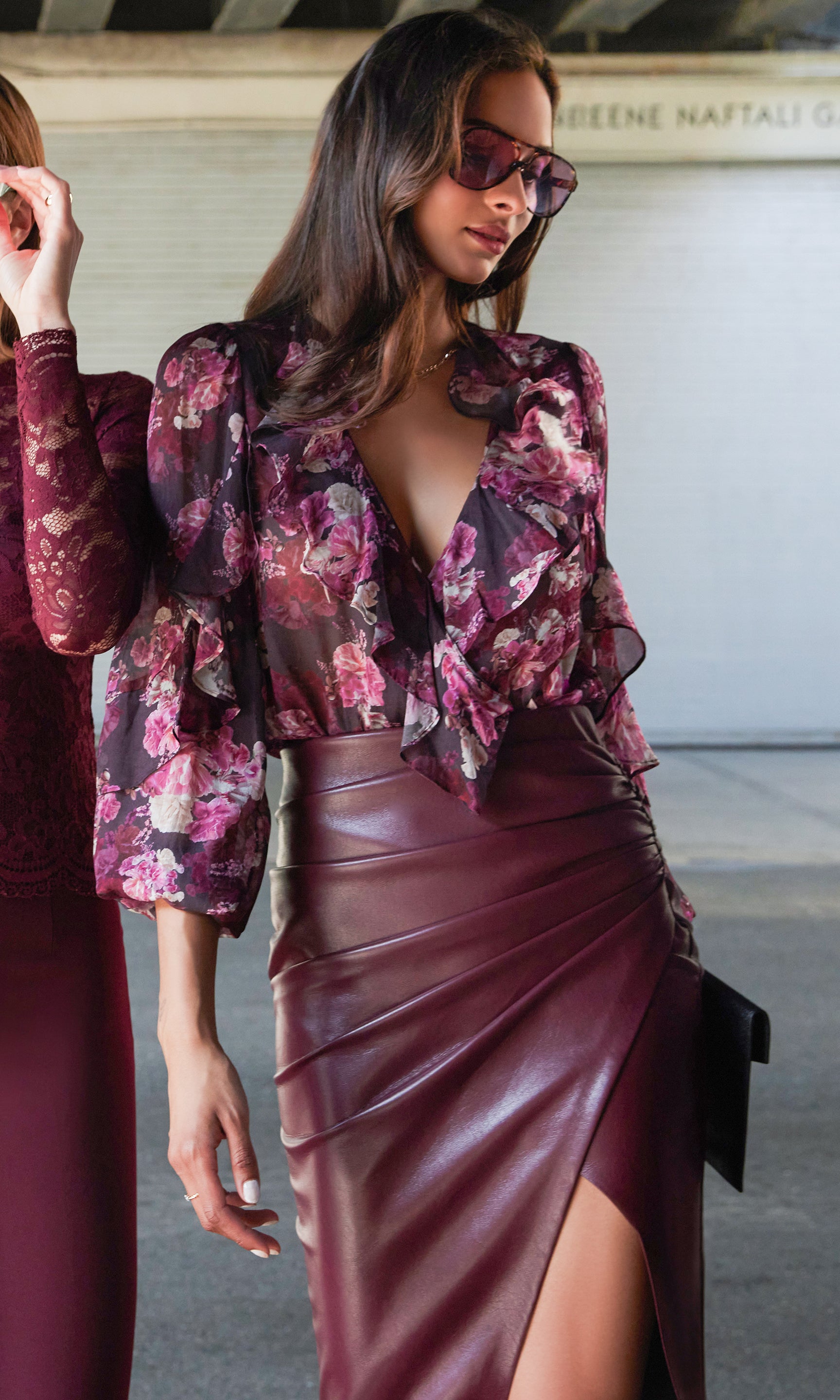 Close-up view highlighting the wrap neckline, floral print, and ruffle-trimmed sleeves of the Nikali Floral Wrap Bodysuit.