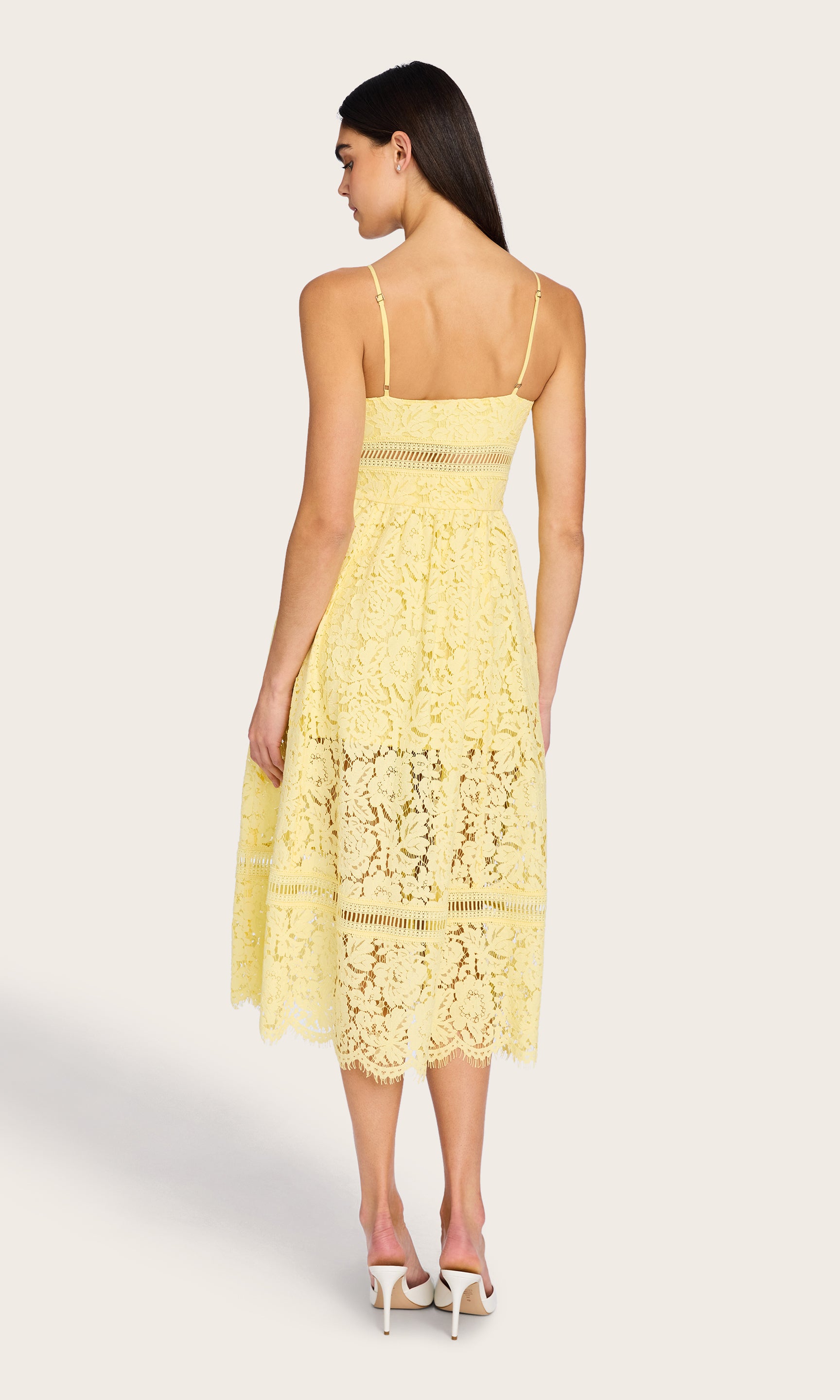 The model wears the Emma Lace Maxi Dress in a full-body rear view, showcasing the delicate lace back detail and the tiered silhouette from behind.