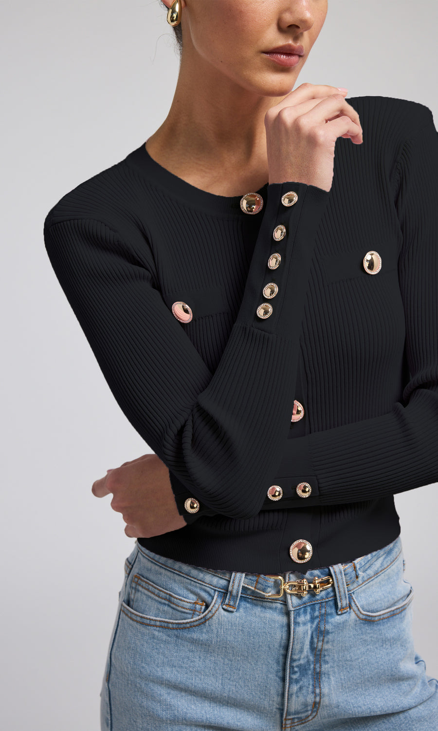 A black ribbed cardigan featuring elegant gold buttons, showcasing a stylish and sophisticated design.