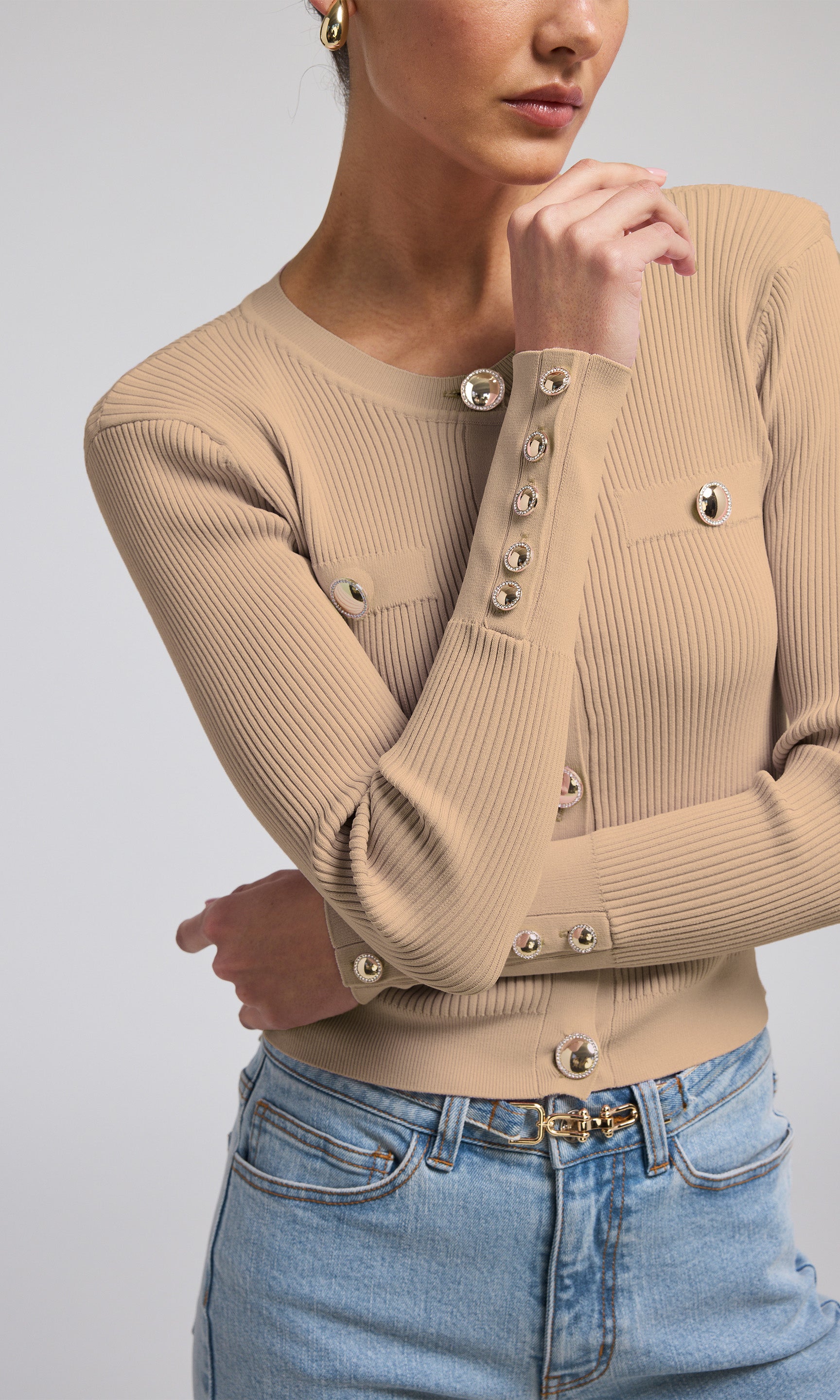 A stylish camel ribbed cardigan with gold buttons, perfect for adding a touch of elegance to any outfit.