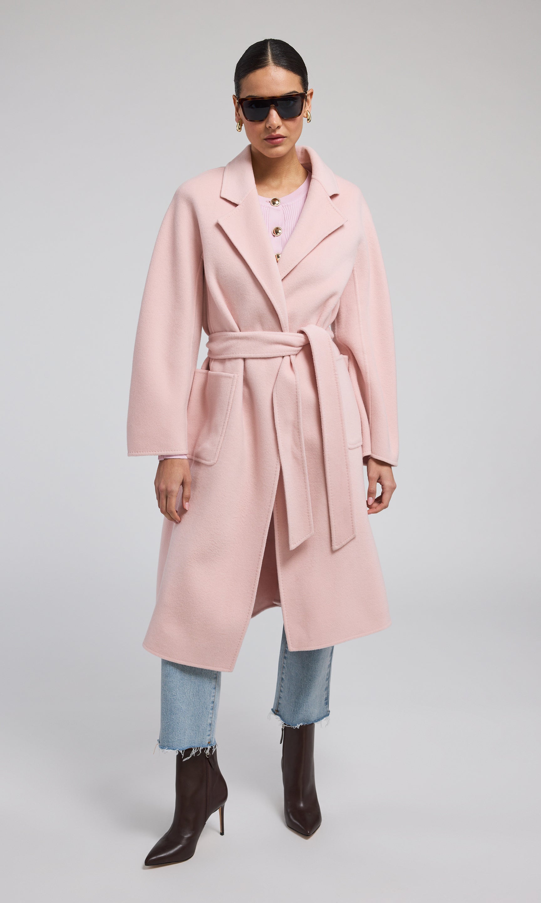 A pink wool coat featuring a stylish belt, showcasing a warm and fashionable design suitable for various occasions.