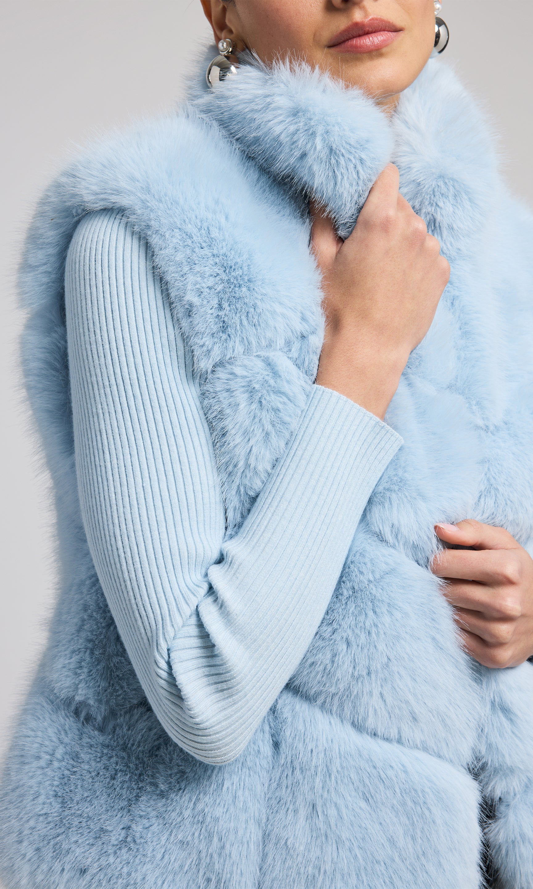 Elegant blue faux fur vest, crafted from high-quality materials, offering a chic and sophisticated look for various occasions.