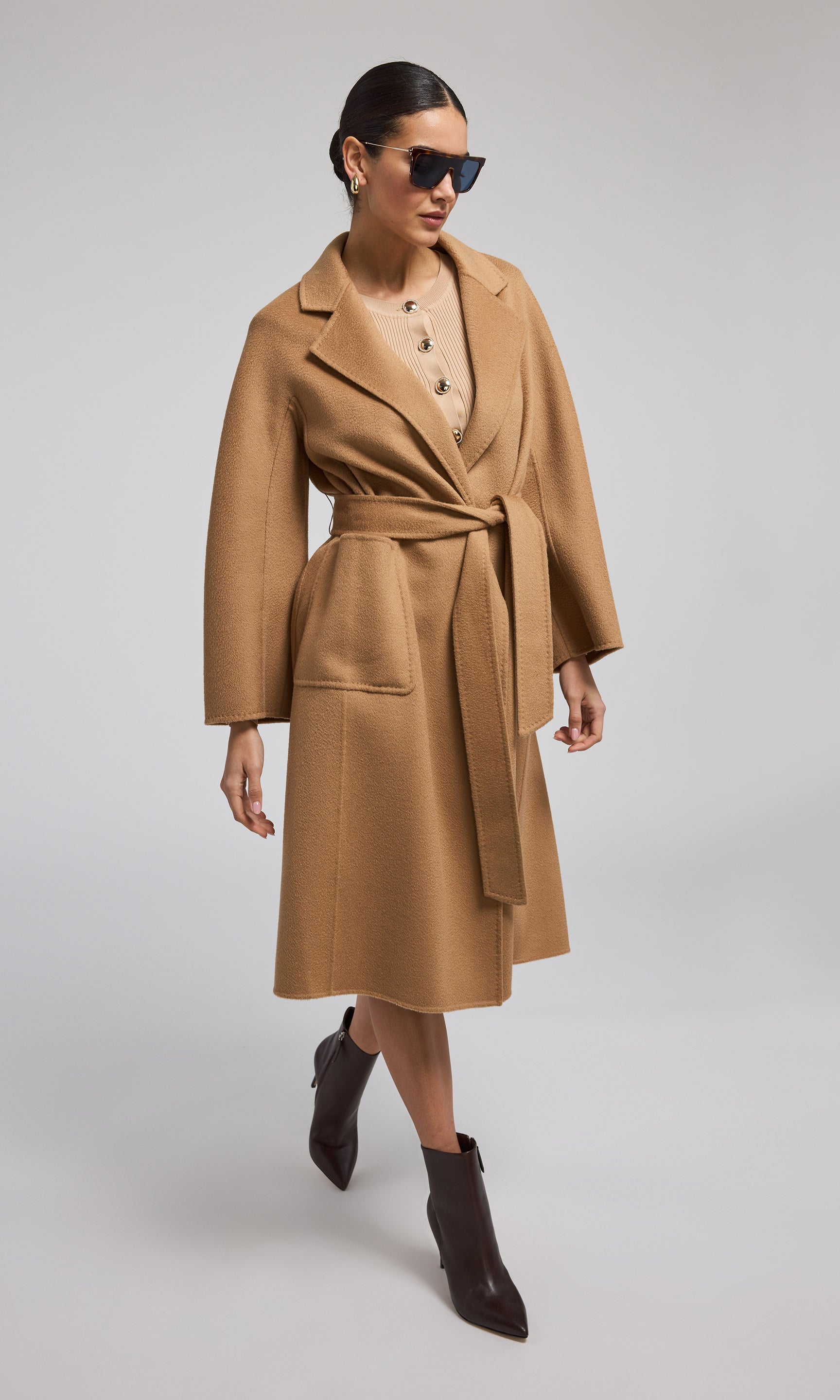  A chic camel wool coat with a belt, emphasizing elegance and warmth in its design for a fashionable look.