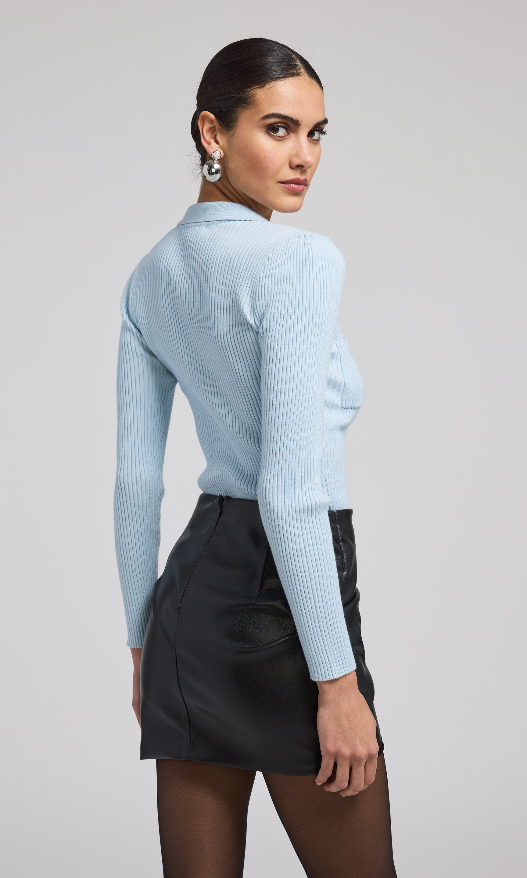 This light blue rib knit sweater is an excellent choice for a laid-back outfit, combining comfort with a fashionable appearance.