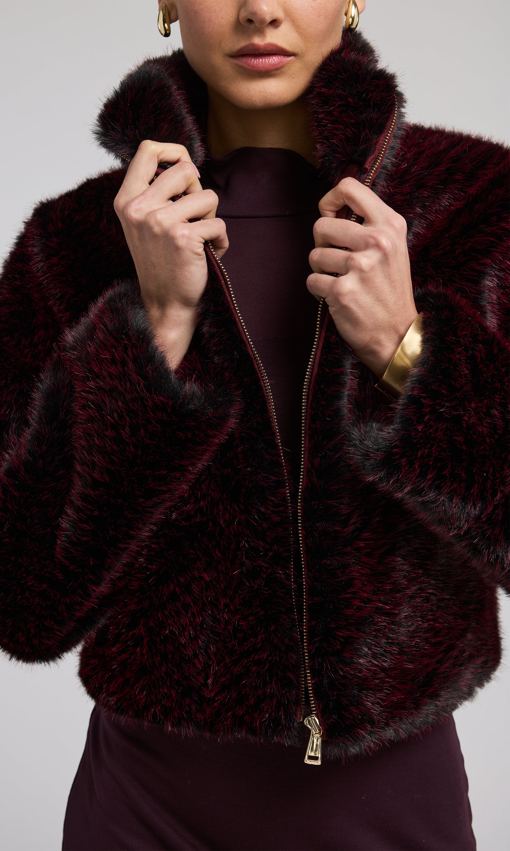 A stylish burgundy black and wine faux fur bomber jacket, perfect for adding warmth and elegance to any outfit.