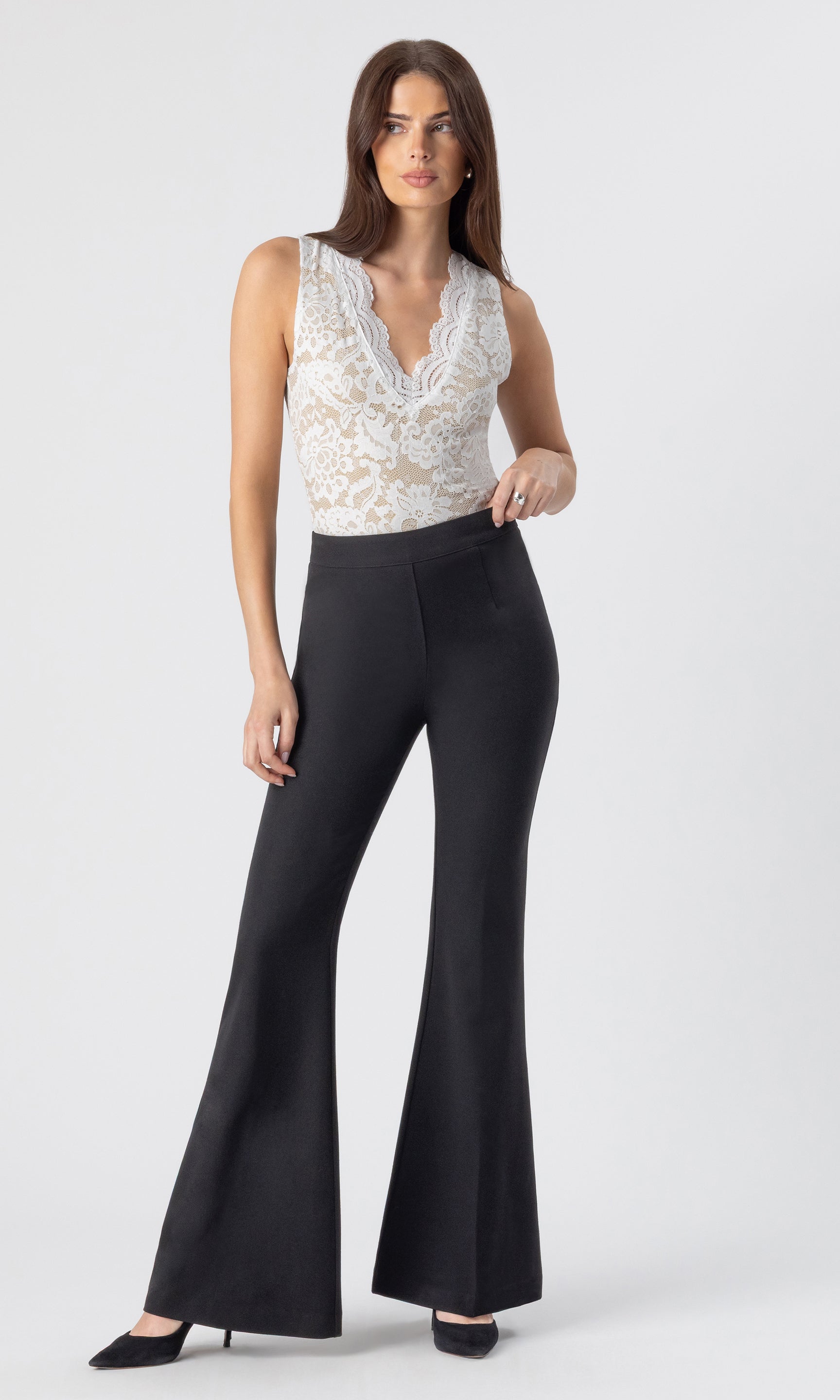 full body image of model wearing the Wesley crepe pants in black, paired with a white/beige lace tank and black heels