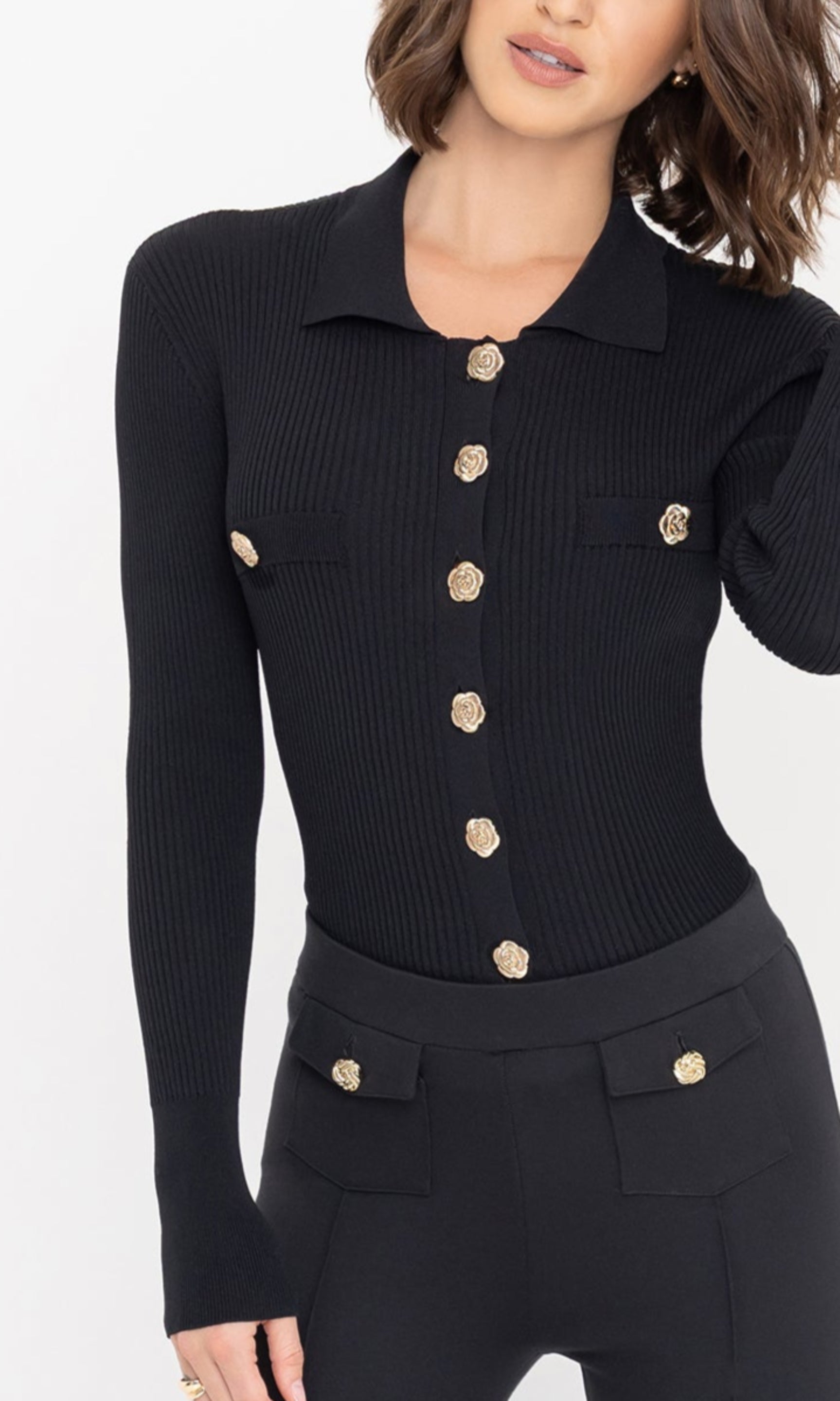 Detail shot of the Carter Rib Cardigan in black, showcasing the gold floral knot buttons