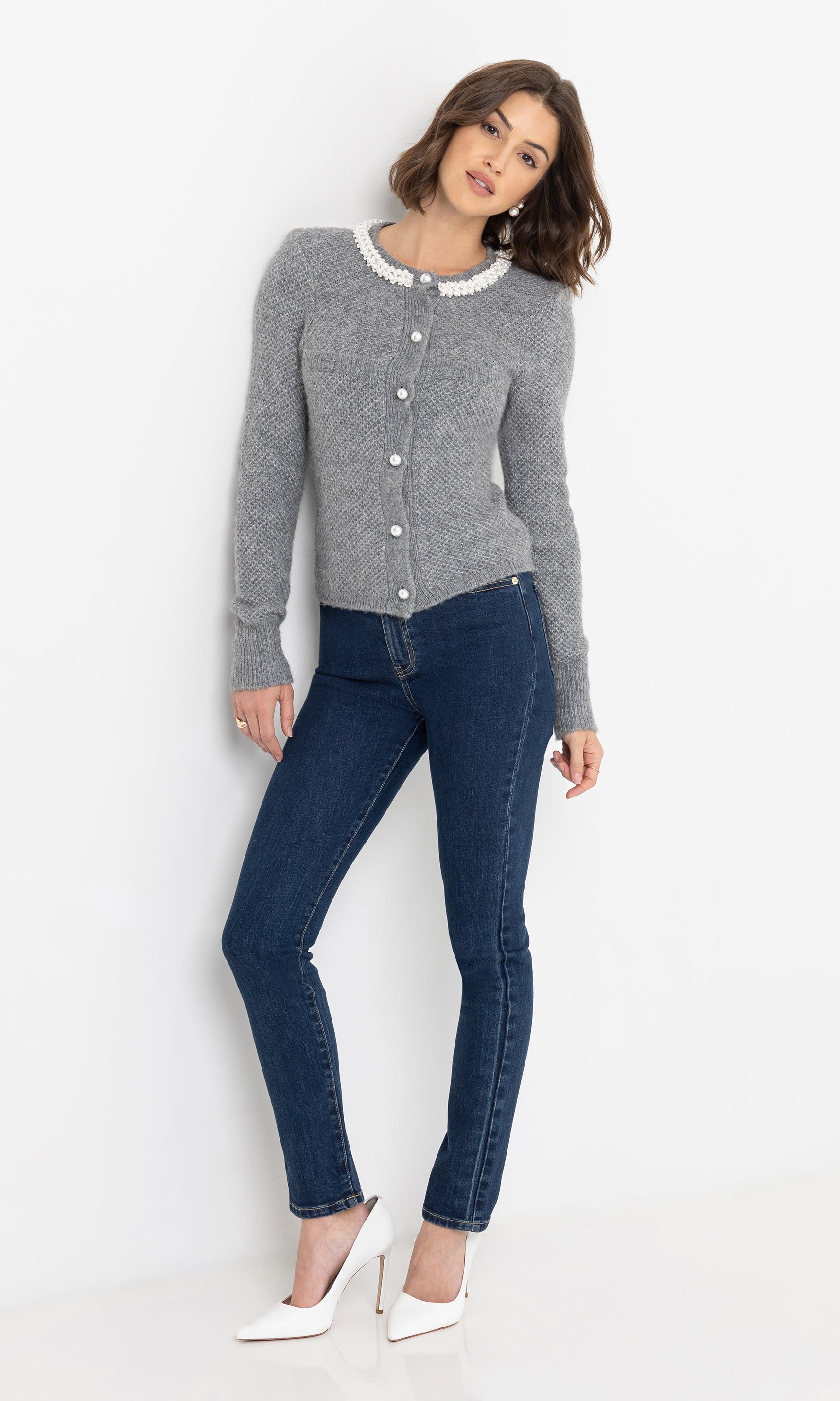 Full body front view of the Clove Cardigan in grey, worn with dark blue skinny jeans.