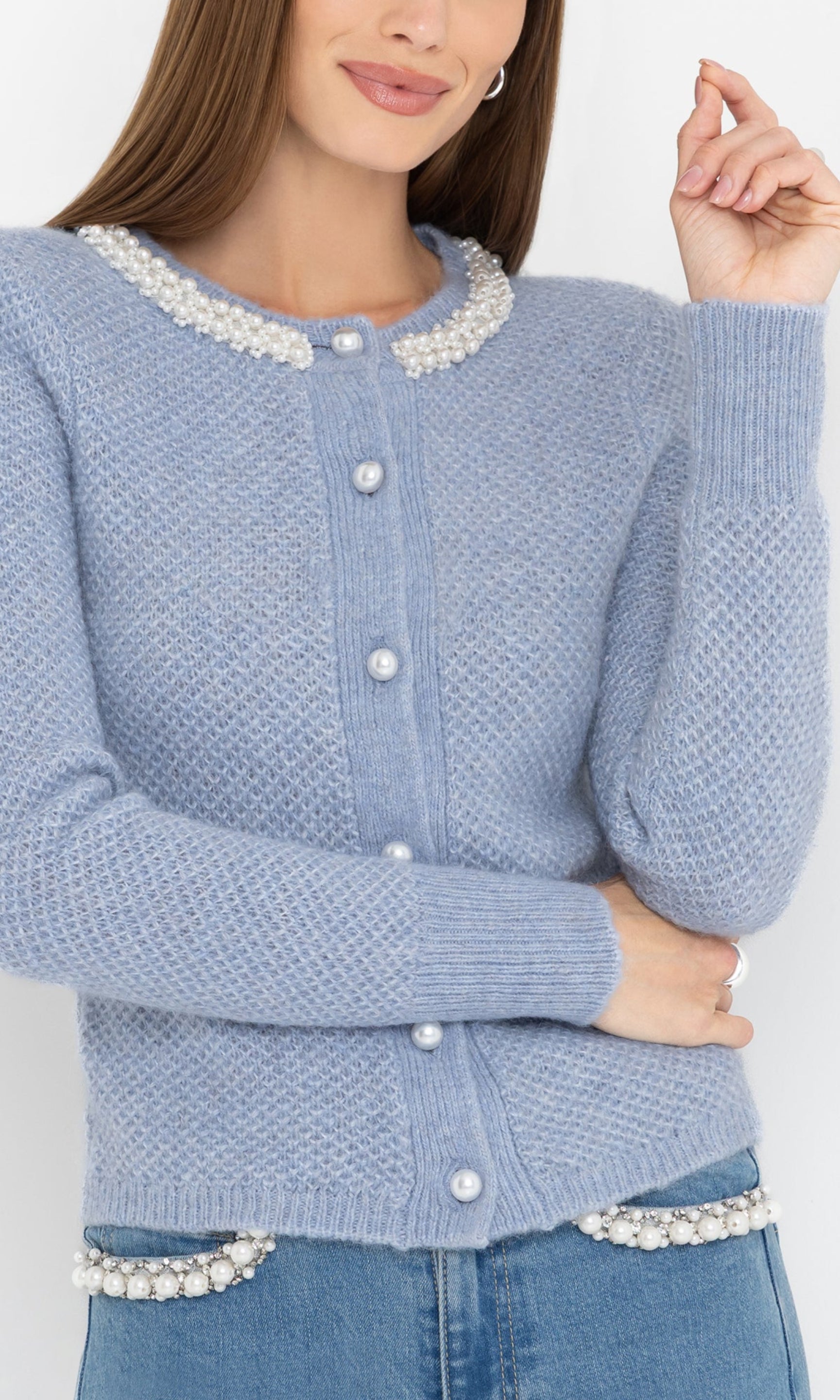 Close-up front view of the Clove Cardigan in soft blue, showcasing the pearl buttons and textured knit fabric.