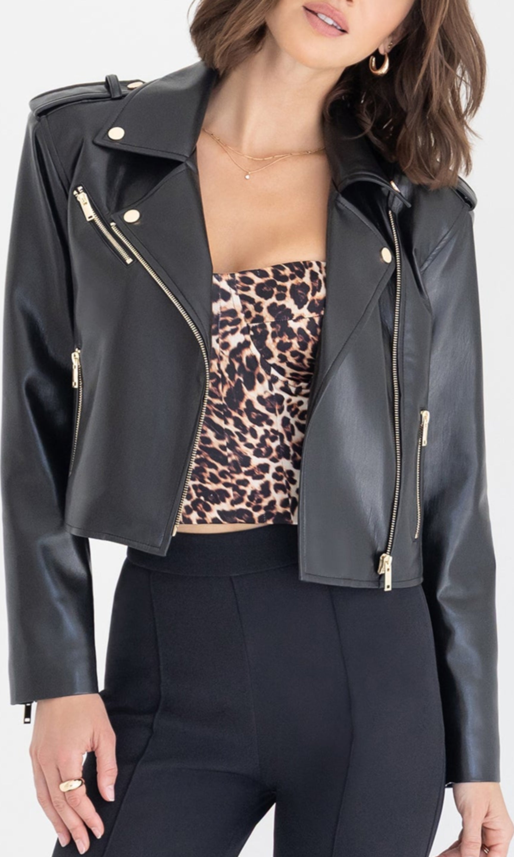 Close-up front view of the Cosita Vegan Leather Jacket worn over a leopard-print top, highlighting the asymmetric zipper and lapel detailing.