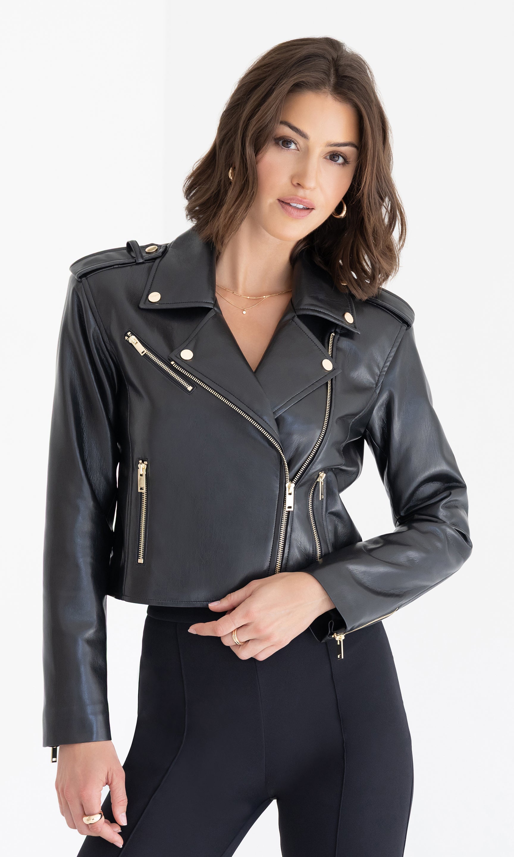 Front view of the Cosita Vegan Leather Jacket in black, styled with gold hardware and paired with black pants.