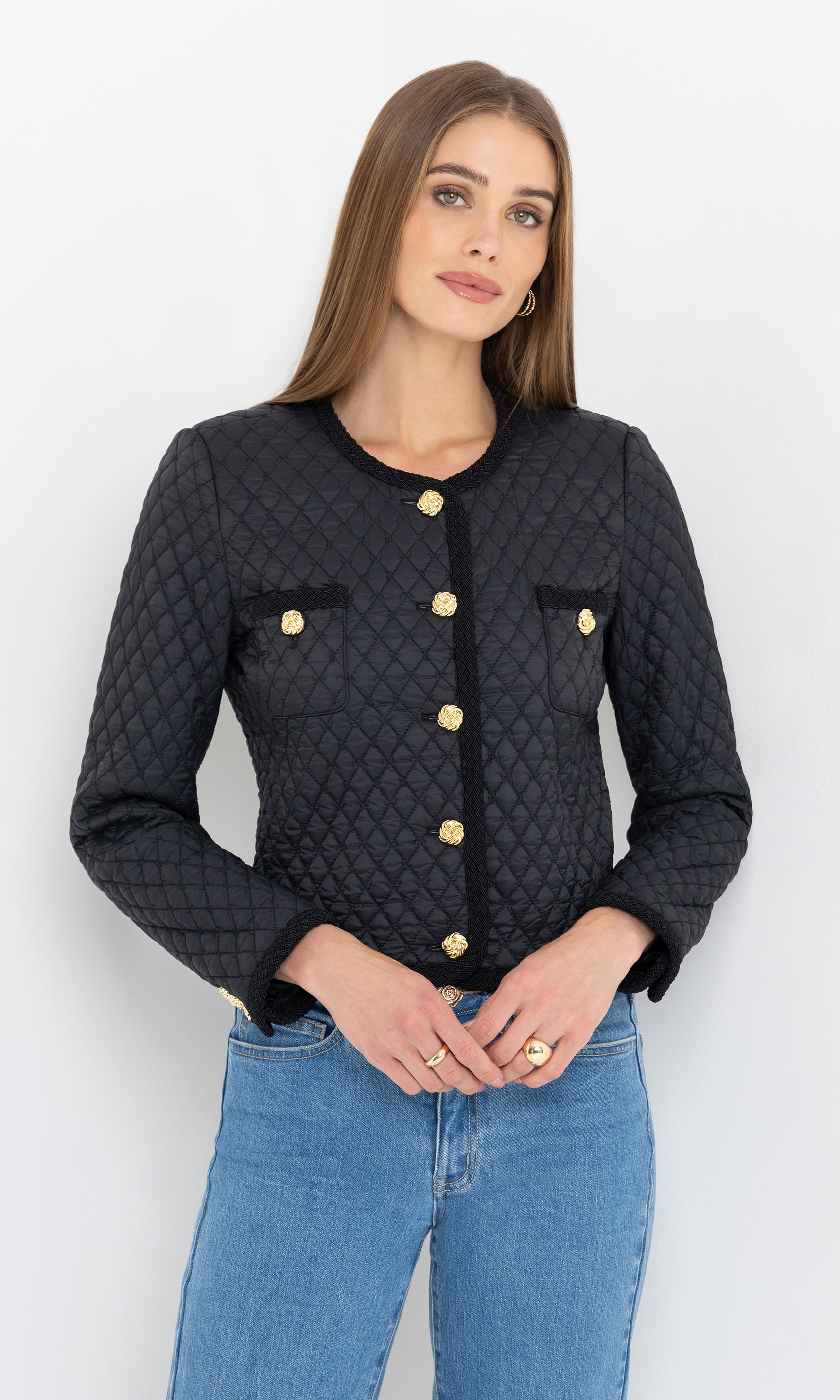A side-angled view of the black everie quilted jacket, showing its textured quilting and gold accents.