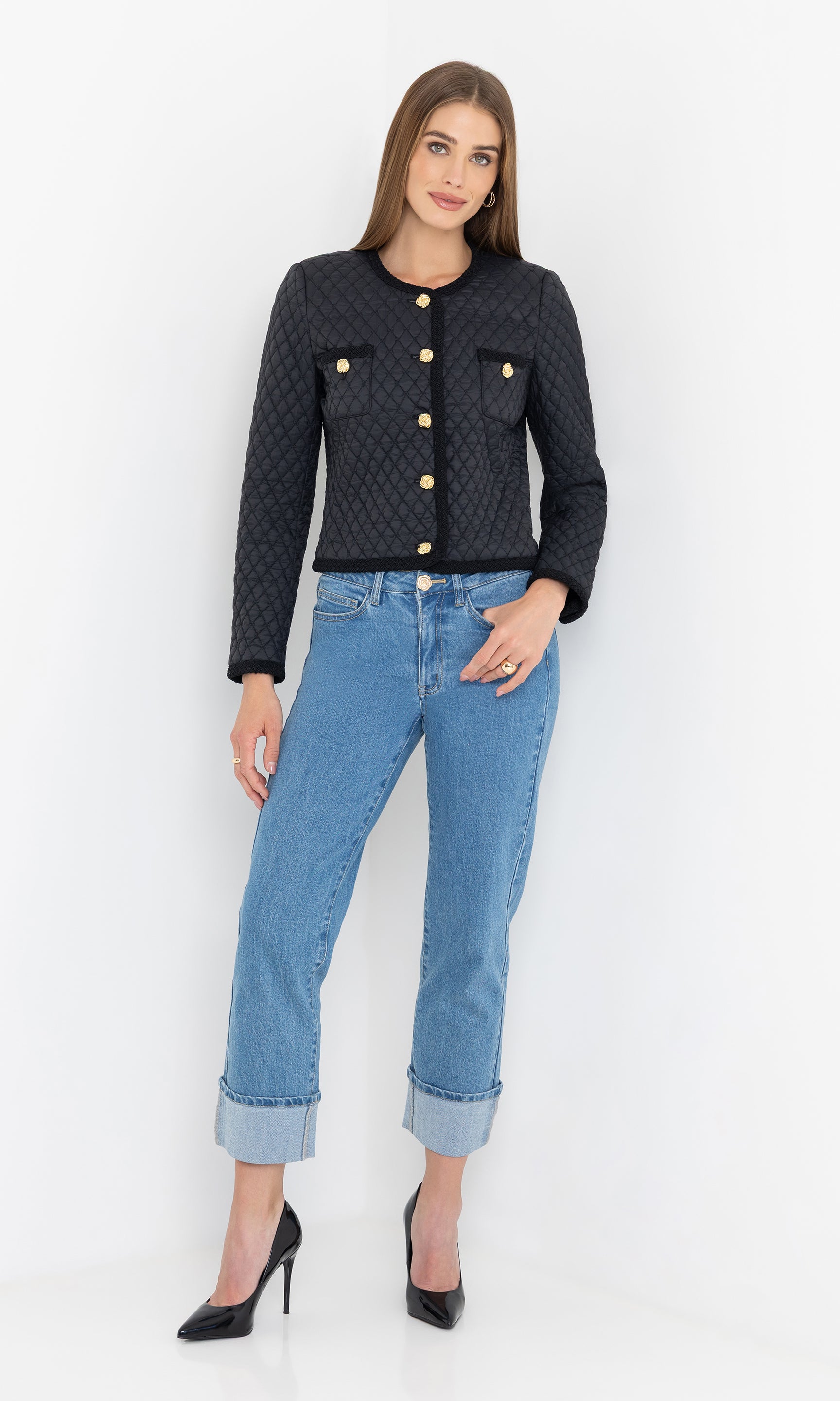 Full-body view of the black everie quilted jacket styled with light blue jeans and heels.