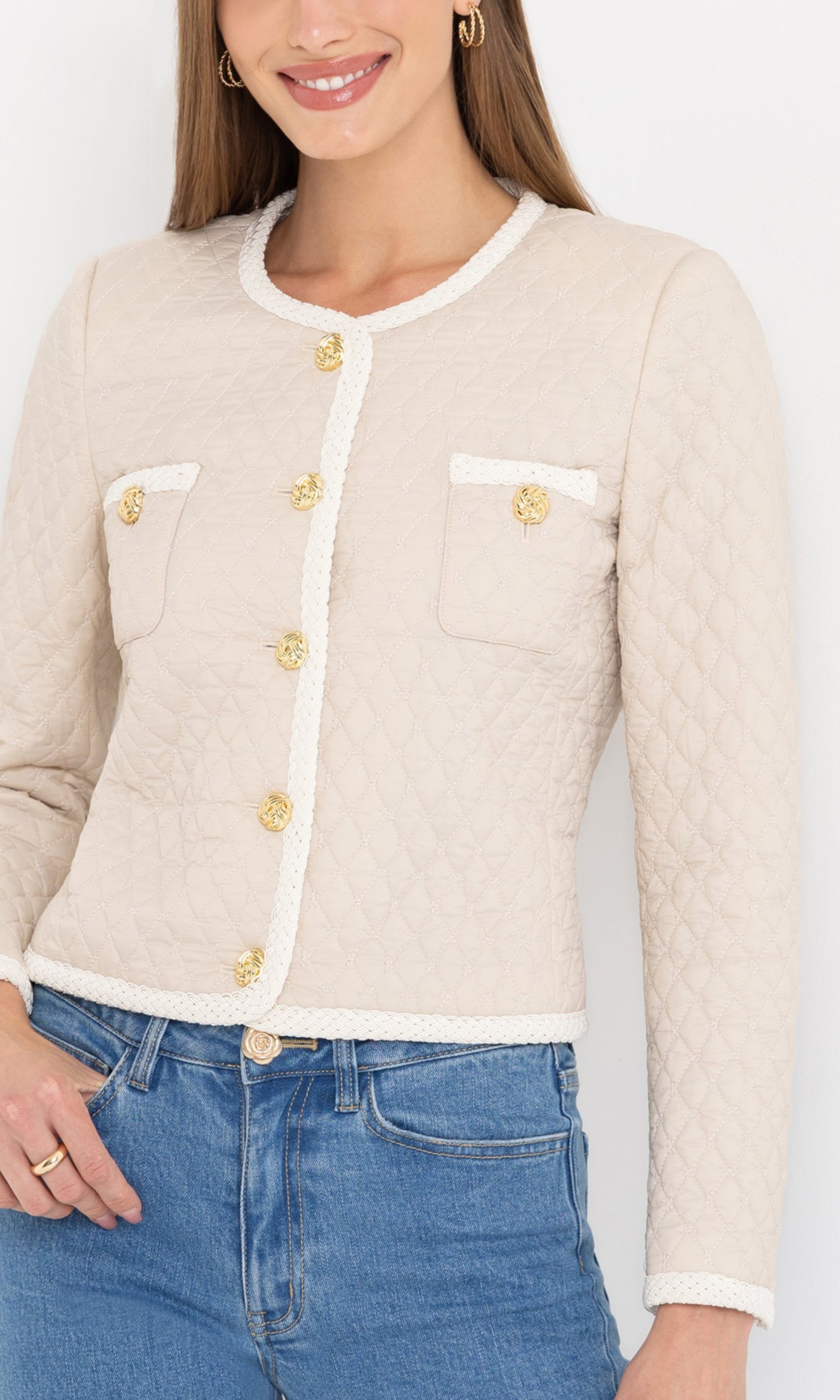 Close-up view highlighting the textured quilting and gold button details of the cream Everie quilted jacket.