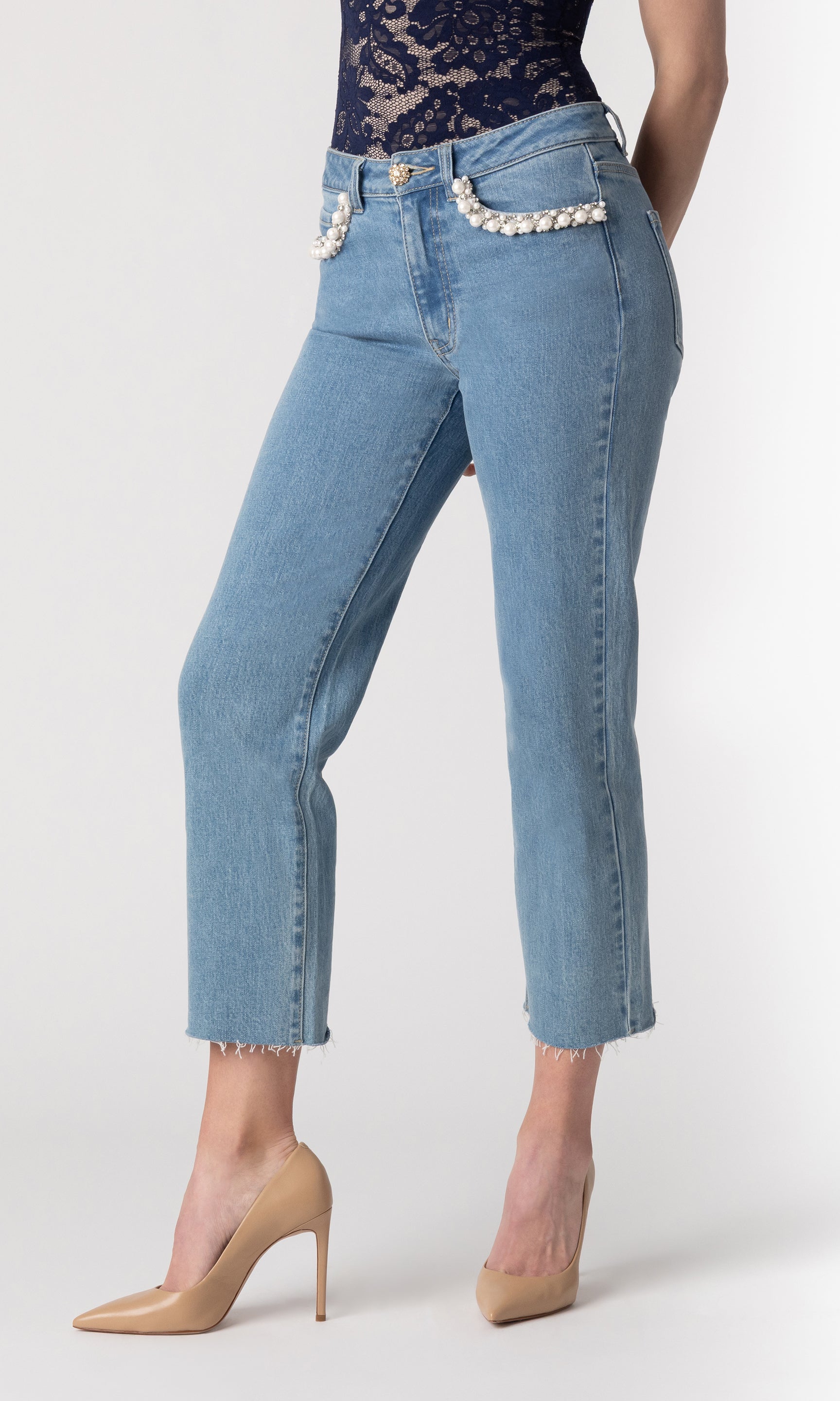 cropped side view image of model wearing the Baylor jeans paired with a navy lace top and beige heels