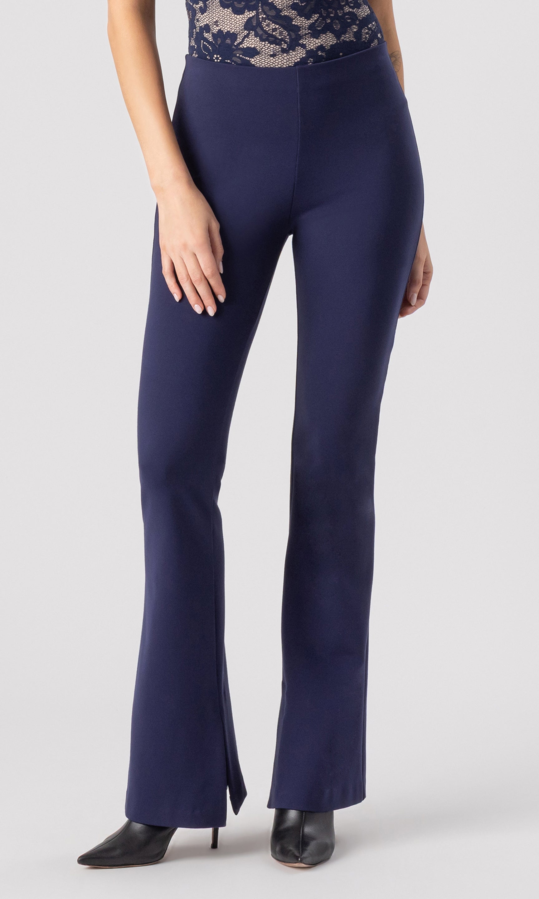 cropped image of model wearing the Murray Ponte Leggings in navy, paired with a navy/beige lace bodysuit and black heeled booties