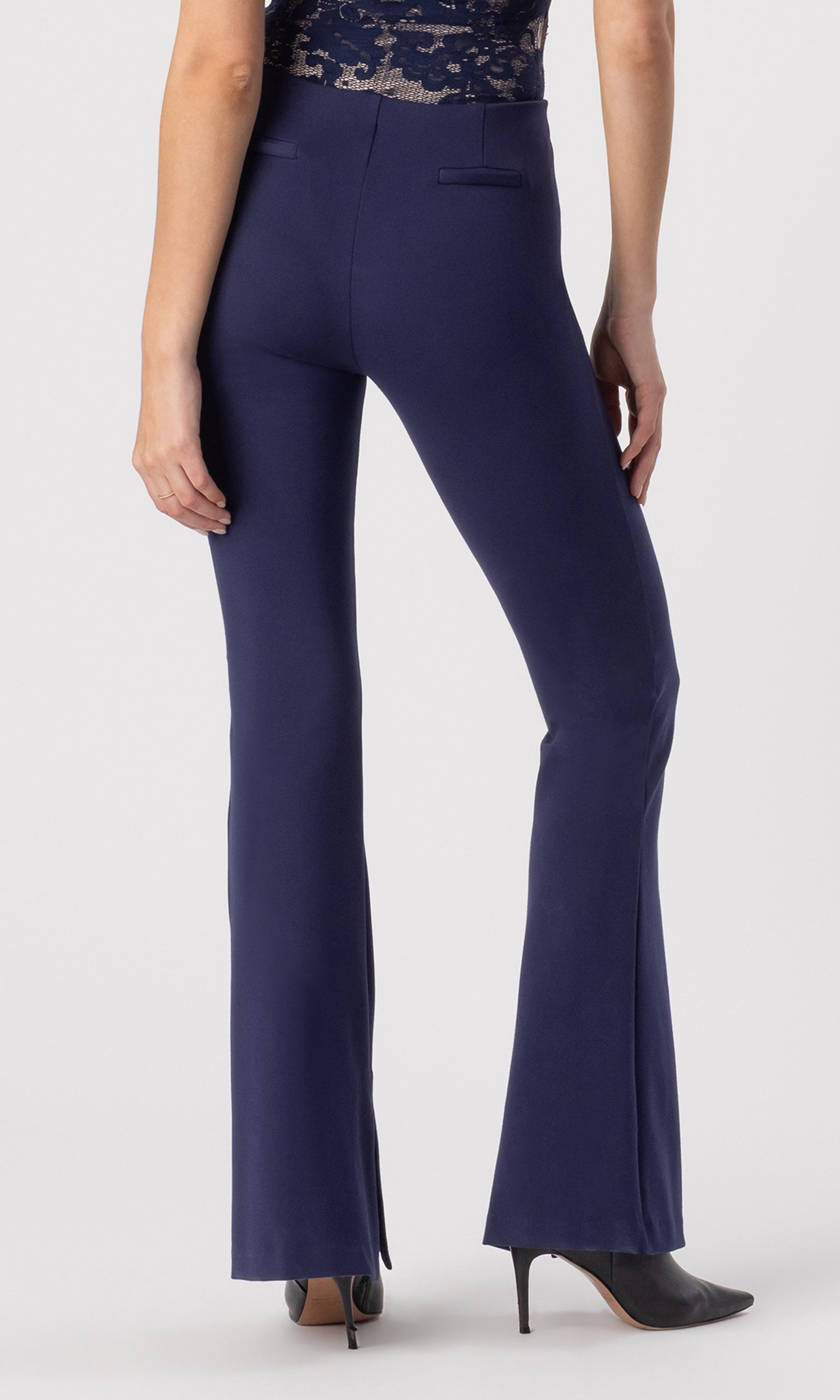 cropped back view image of model wearing the Murray Ponte Leggings in navy, paired with a navy/beige lace bodysuit and black heeled booties