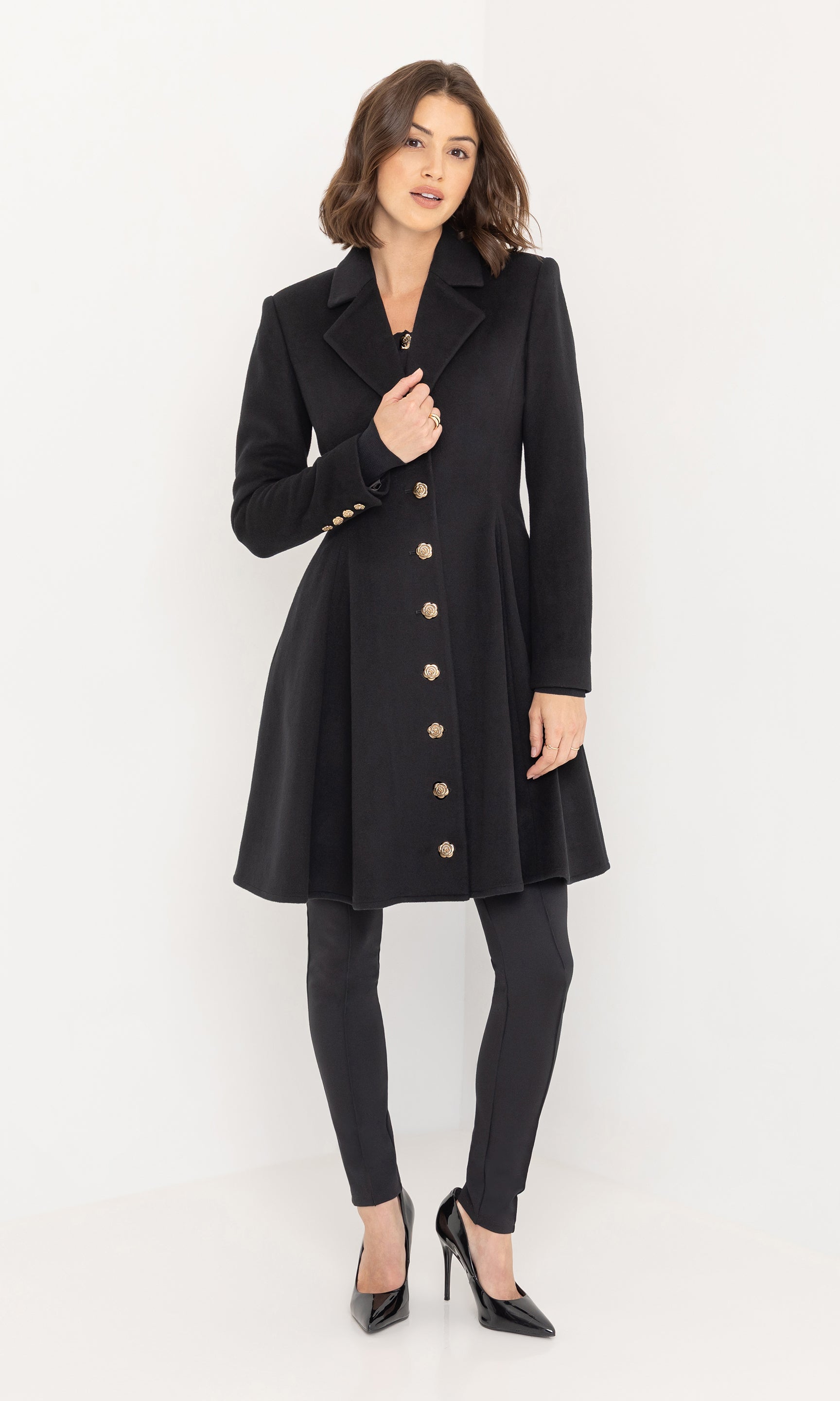 Standing pose in the Judy Wool Coat, emphasizing its elegant drape and versatile black design.