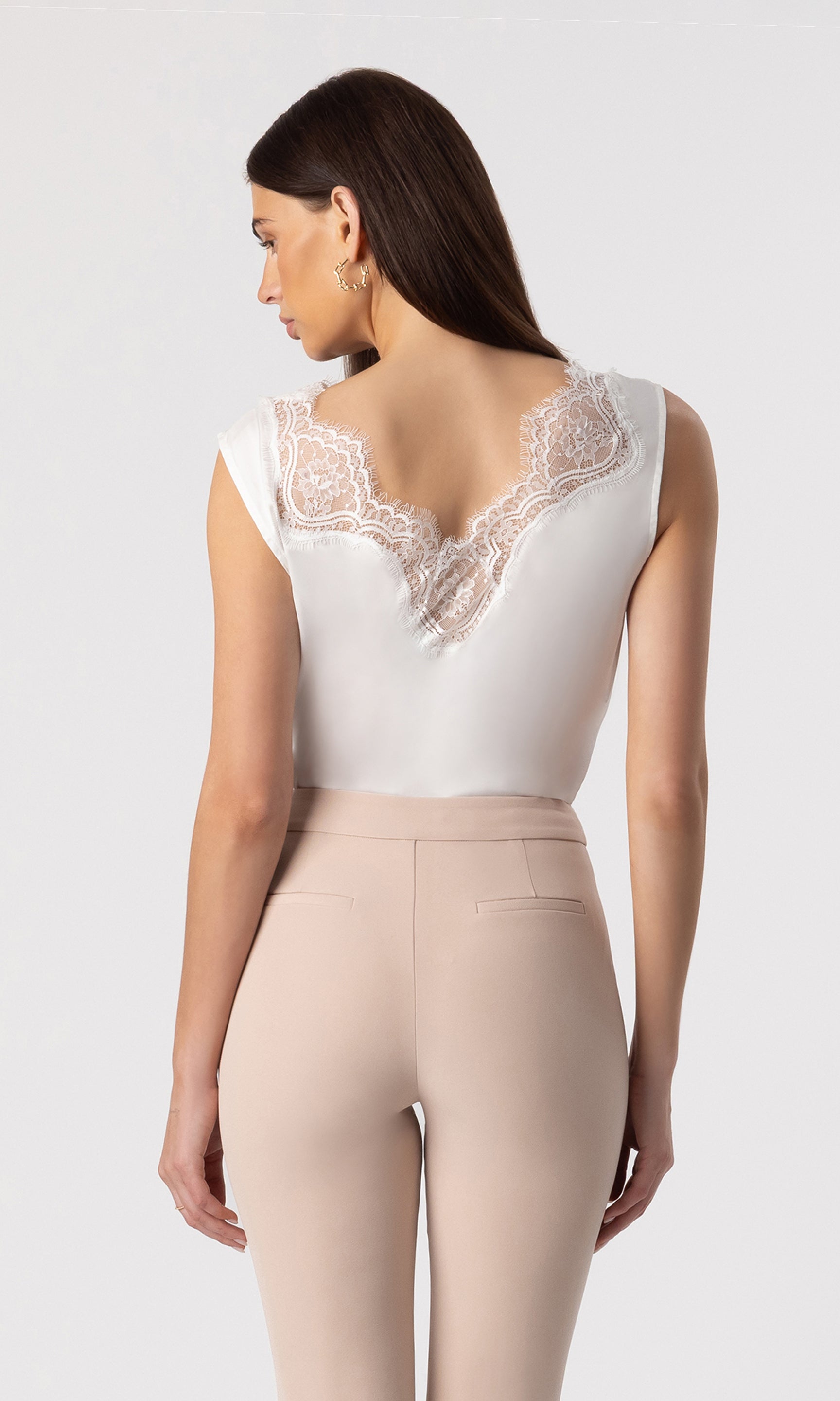 back view image of model wearing the Gladis tank in white, paired with beige trousers