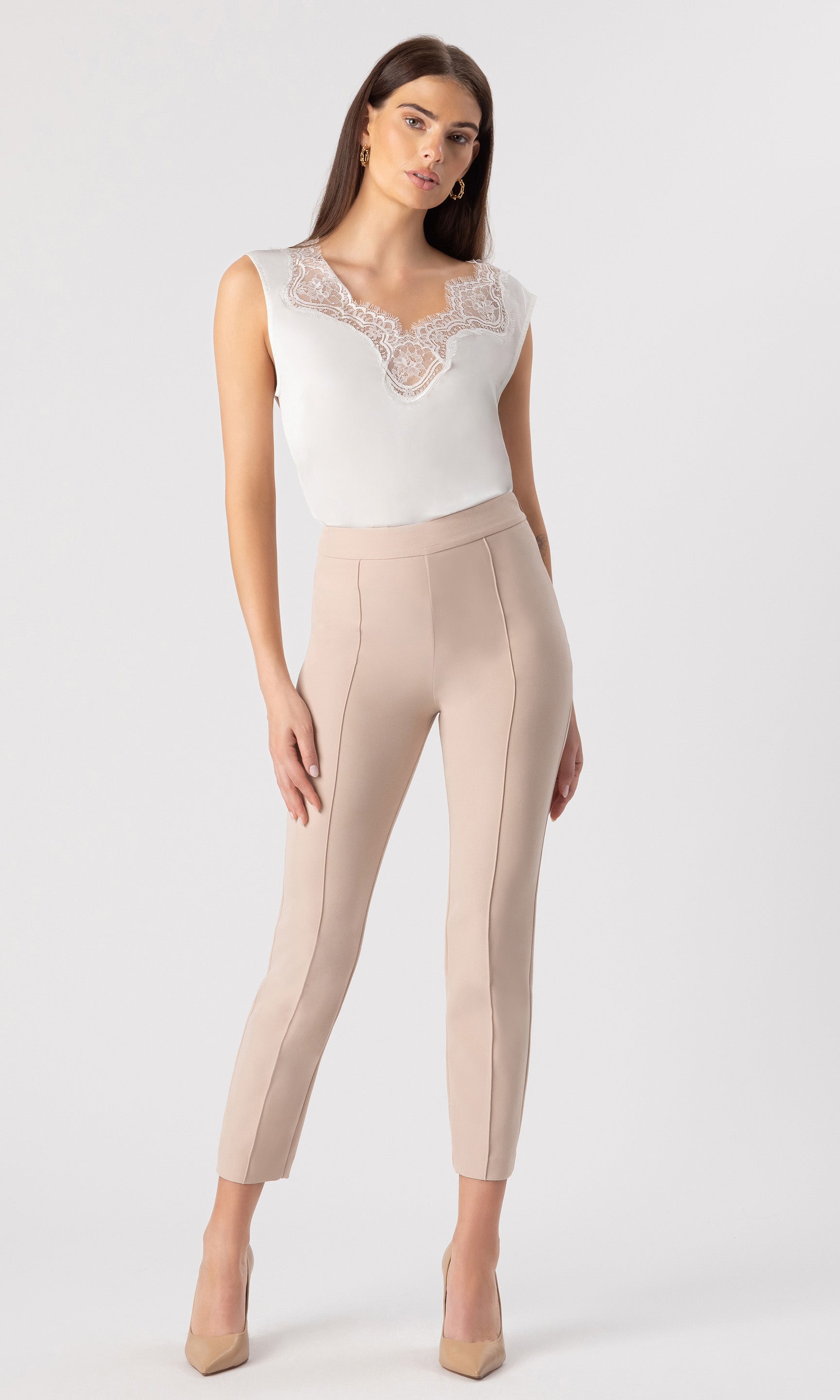 full body image of model wearing the Gladis tank in white, paired with beige trousers and beige heels
