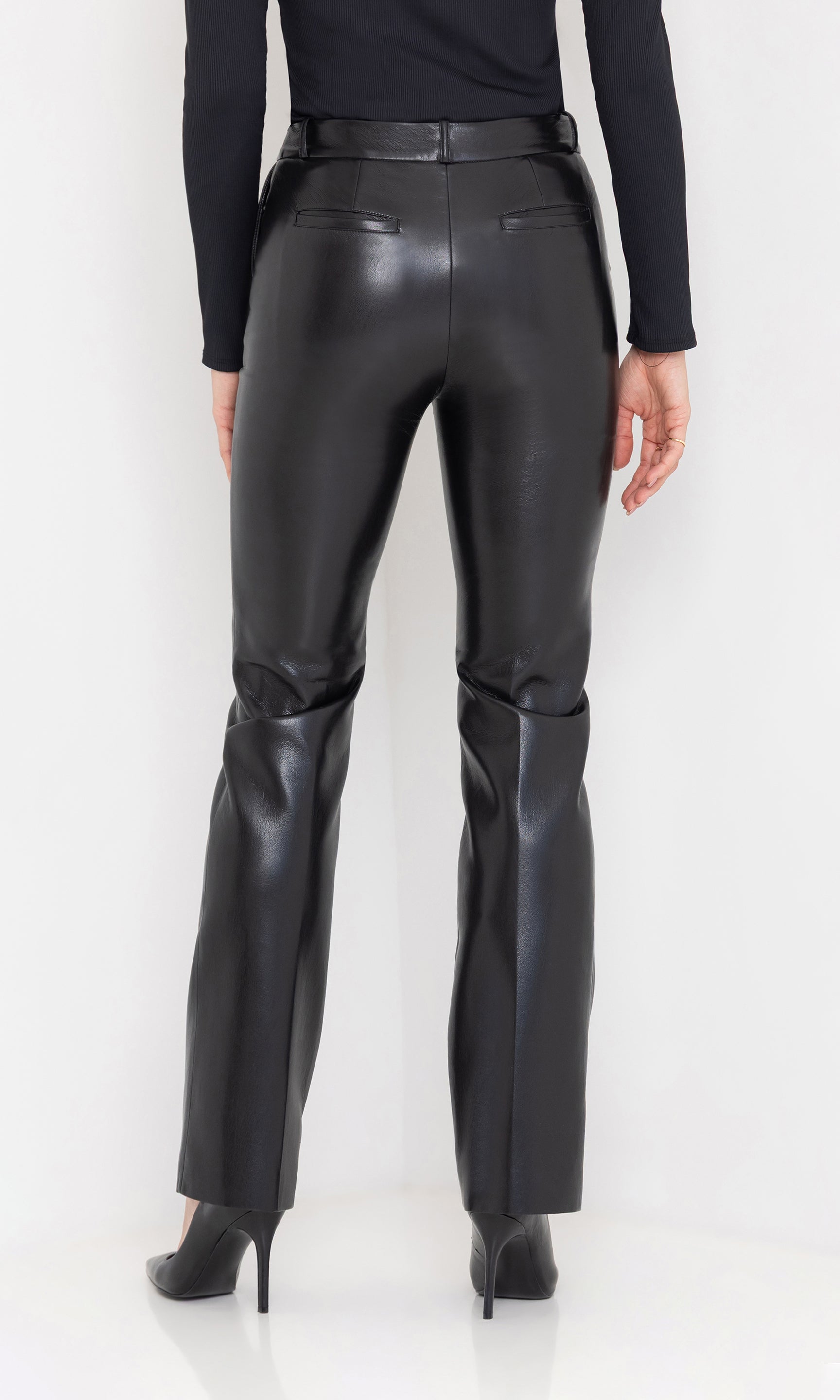 Rear view highlighting the sleek fit and straight-leg silhouette of the vegan leather pants.