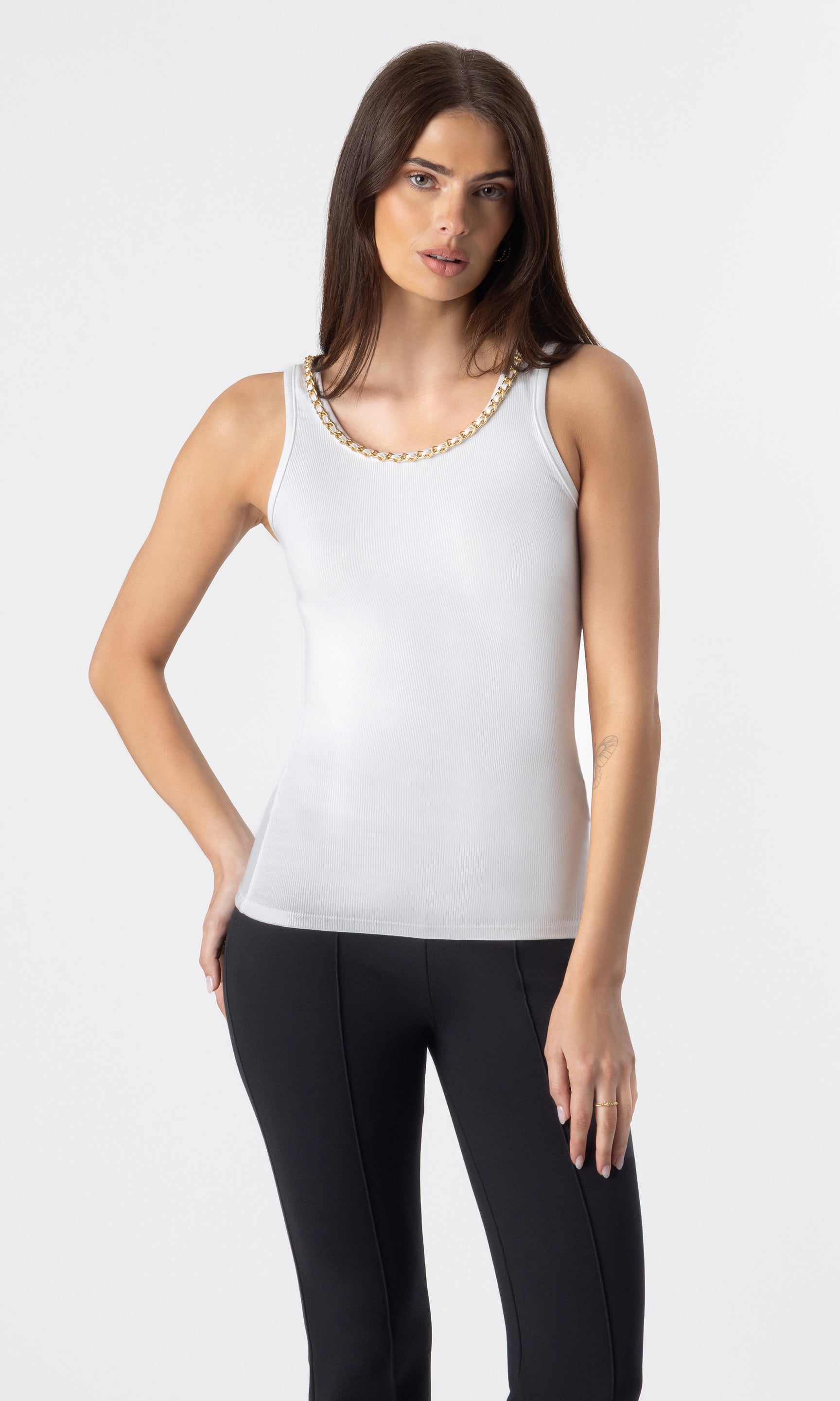 image of model wearing the Mabel tank in white with a chain embellished neckline paired with black leggings