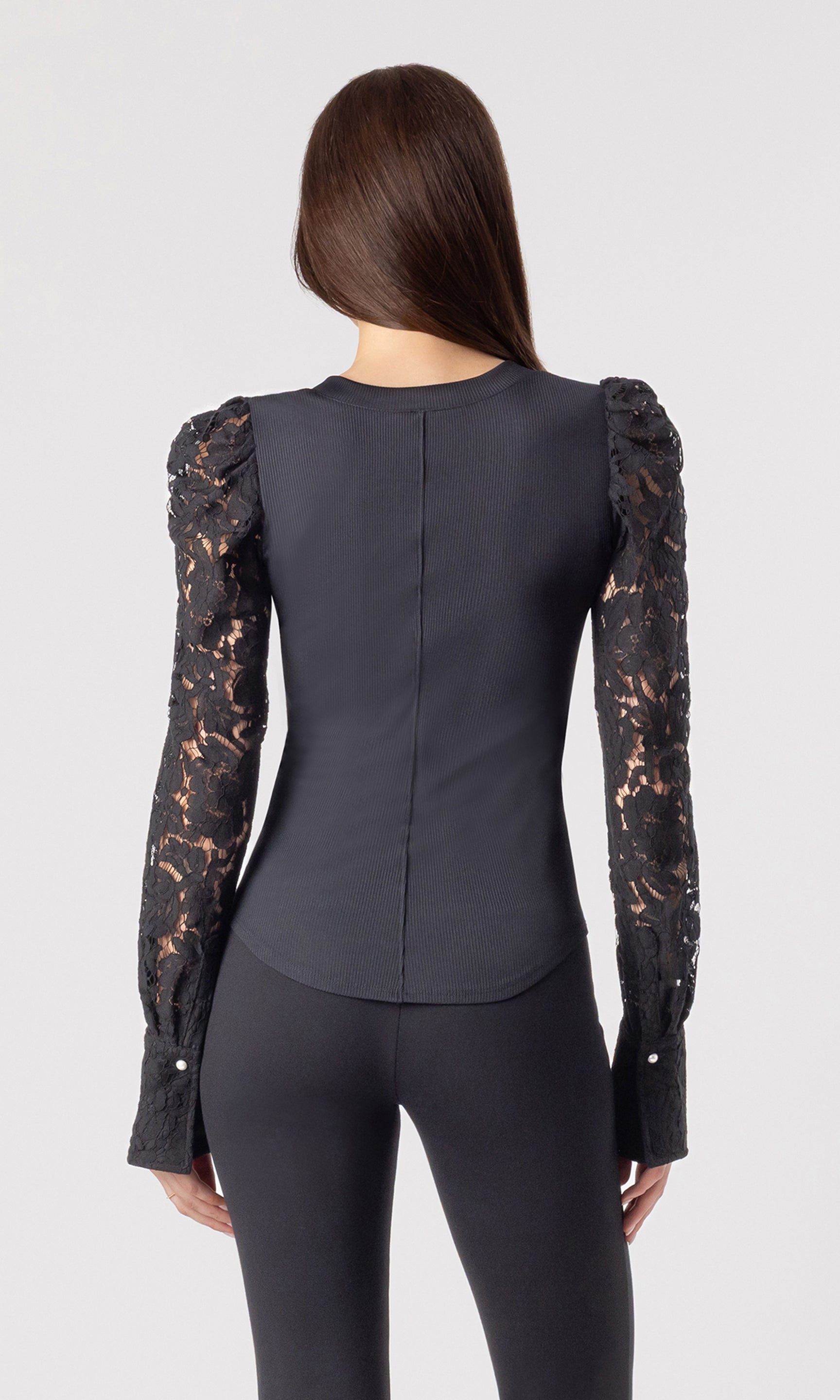 back view image of model wearing the Macoy top in black with matching black leggings