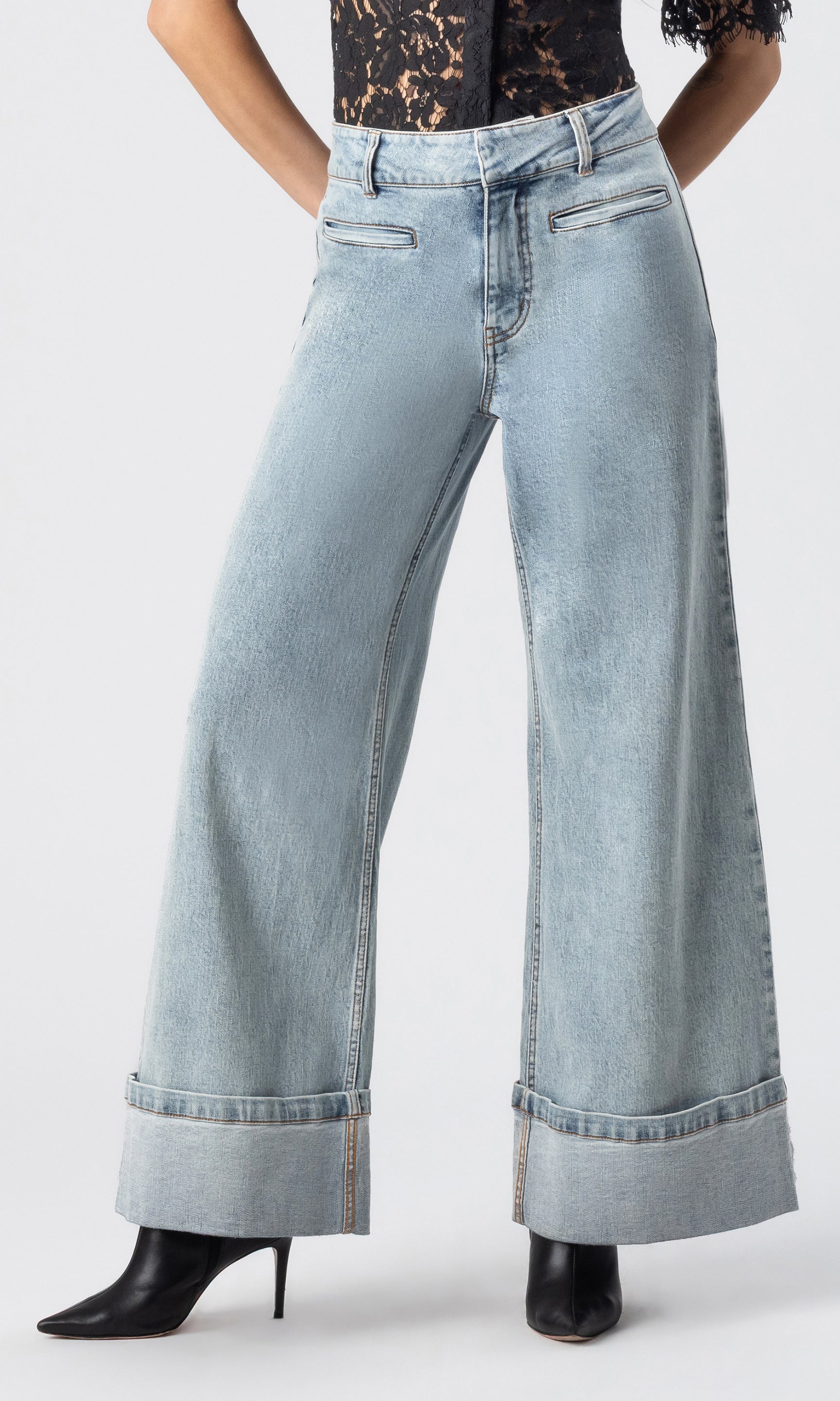 cropped image of model wearing the Raquel denim jeans in light blue, paired with a black lace top and black heeled booties