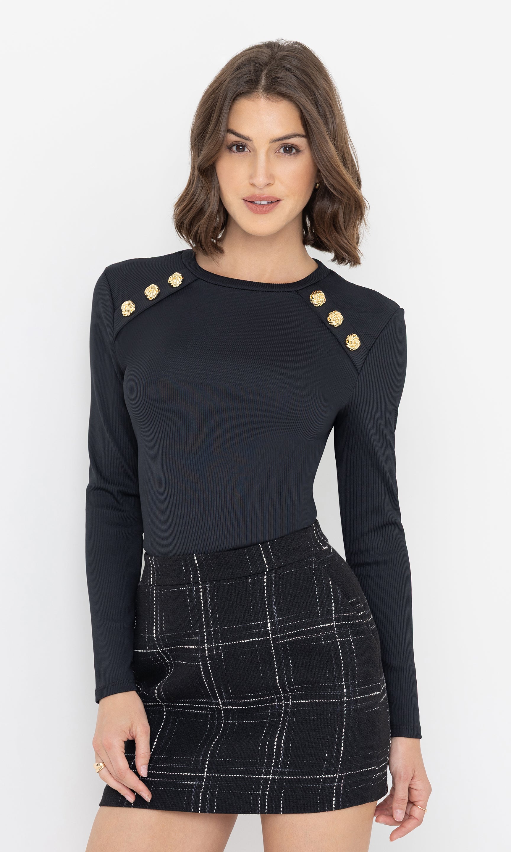 Three-quarter front view of the model showcasing the Patton Rib Top’s gold button details on the shoulders.