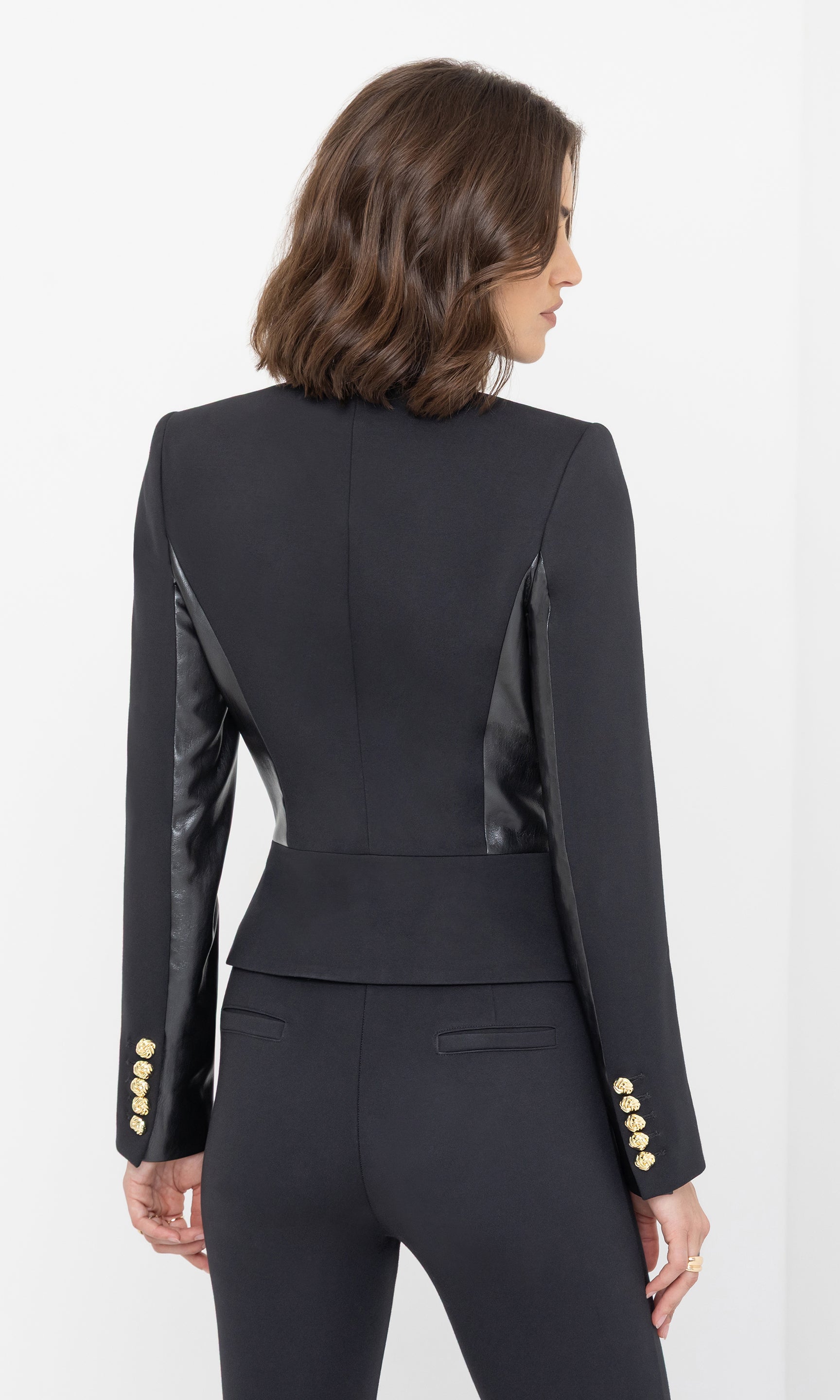 Rear view of the model wearing the Robby Vegan Leather Combo Ponte Jacket in black, displaying the smooth back design and structured silhouette.