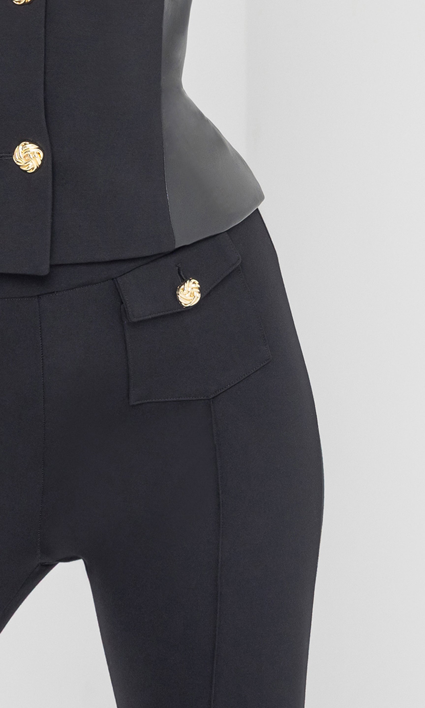 Close-up of Roy Ponte Leggings waistline, showcasing the structured ponte fabric and gold button accents.