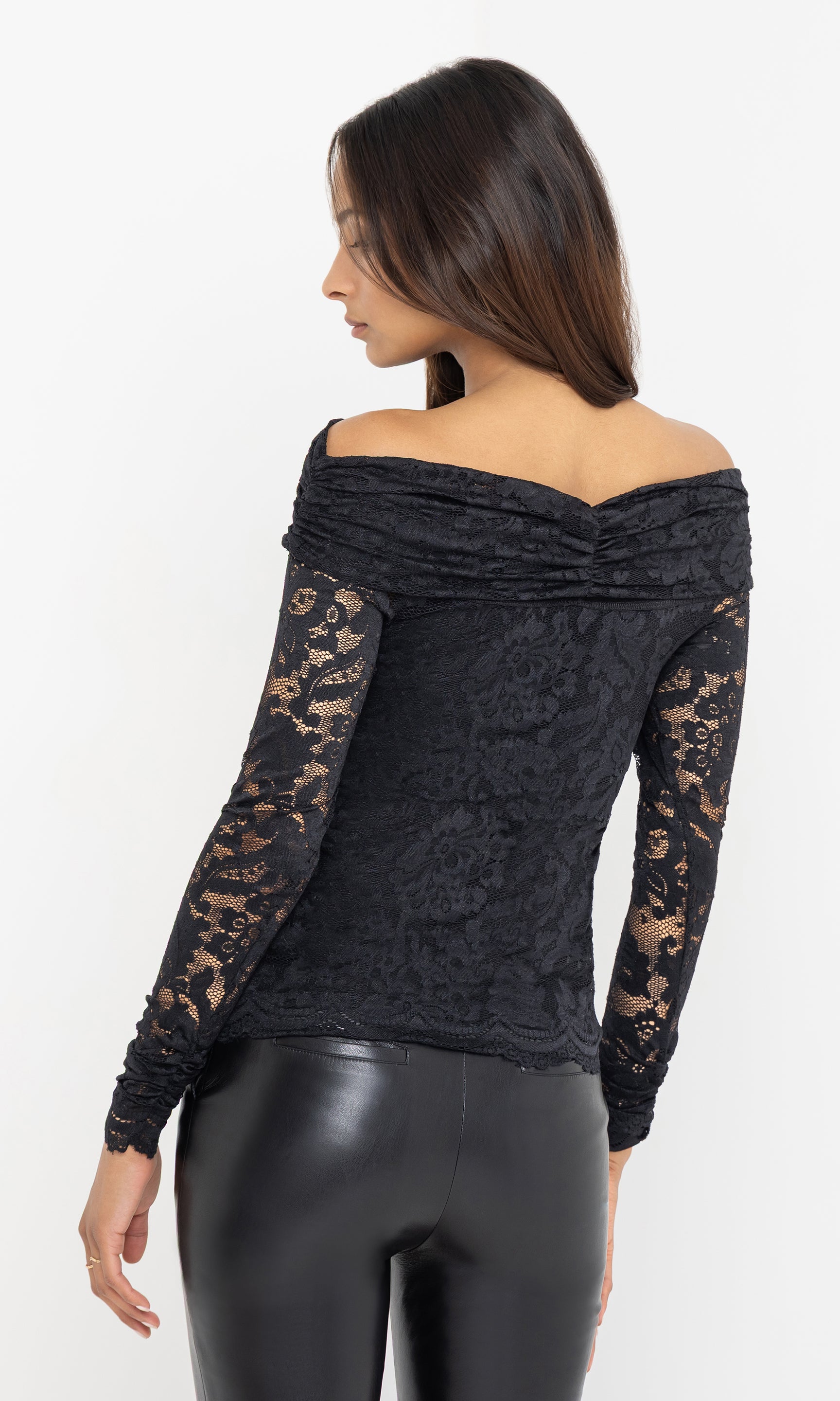Side view of the model in the Romeo Lace Top, showing the delicate lace sleeve detail and fitted silhouette against black leather pants.