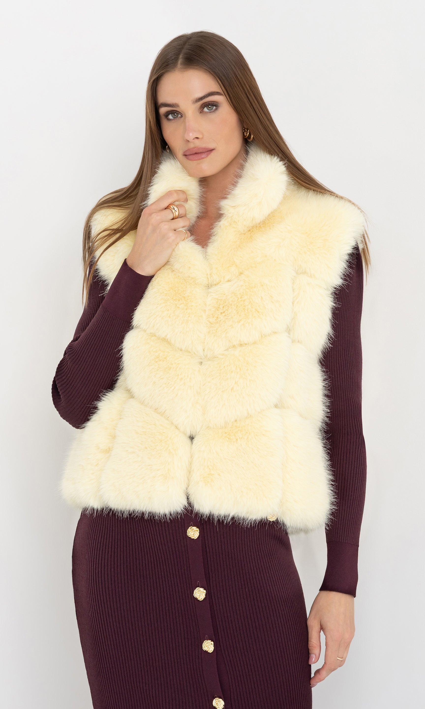 Front view of Rosario Faux Fur Vest in cream, paired with a burgundy long-sleeve dress for a chic winter look.