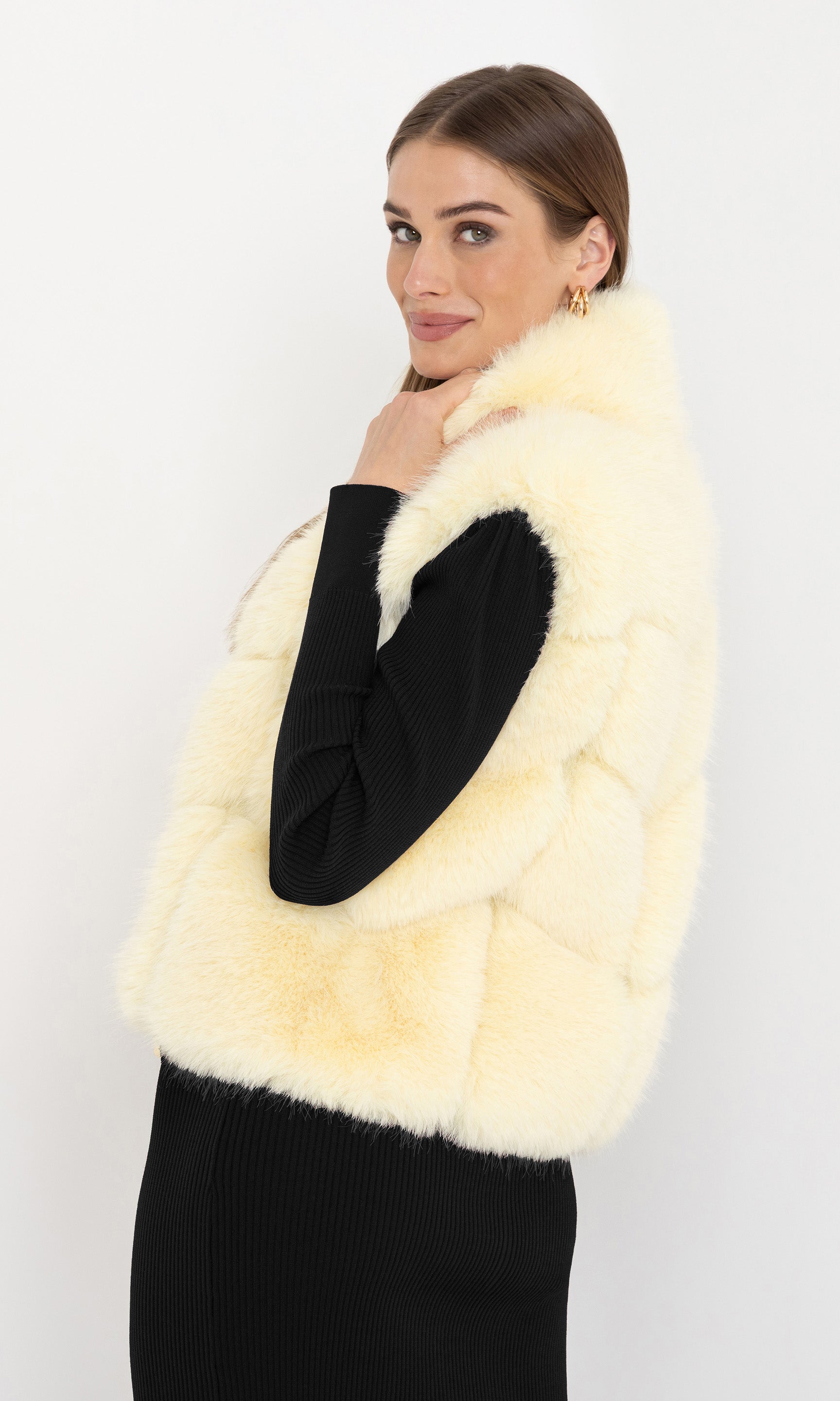 Side angled view of Rosario Faux Fur Vest in cream, showcasing its flattering fit and cozy design.