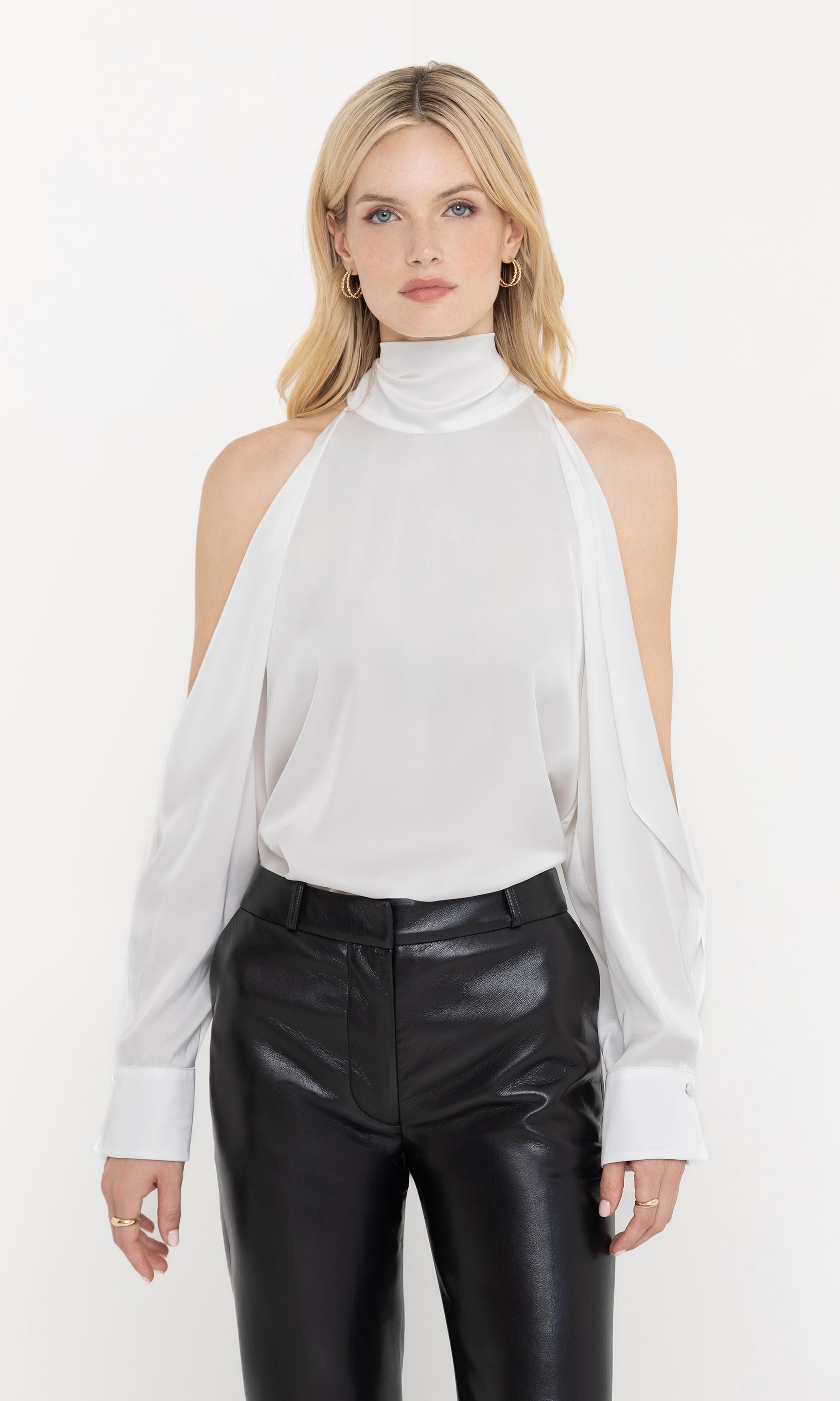 Front view of Rossi Halter Blouse in white, featuring open shoulders and a flowy fit, paired with black leather pants.