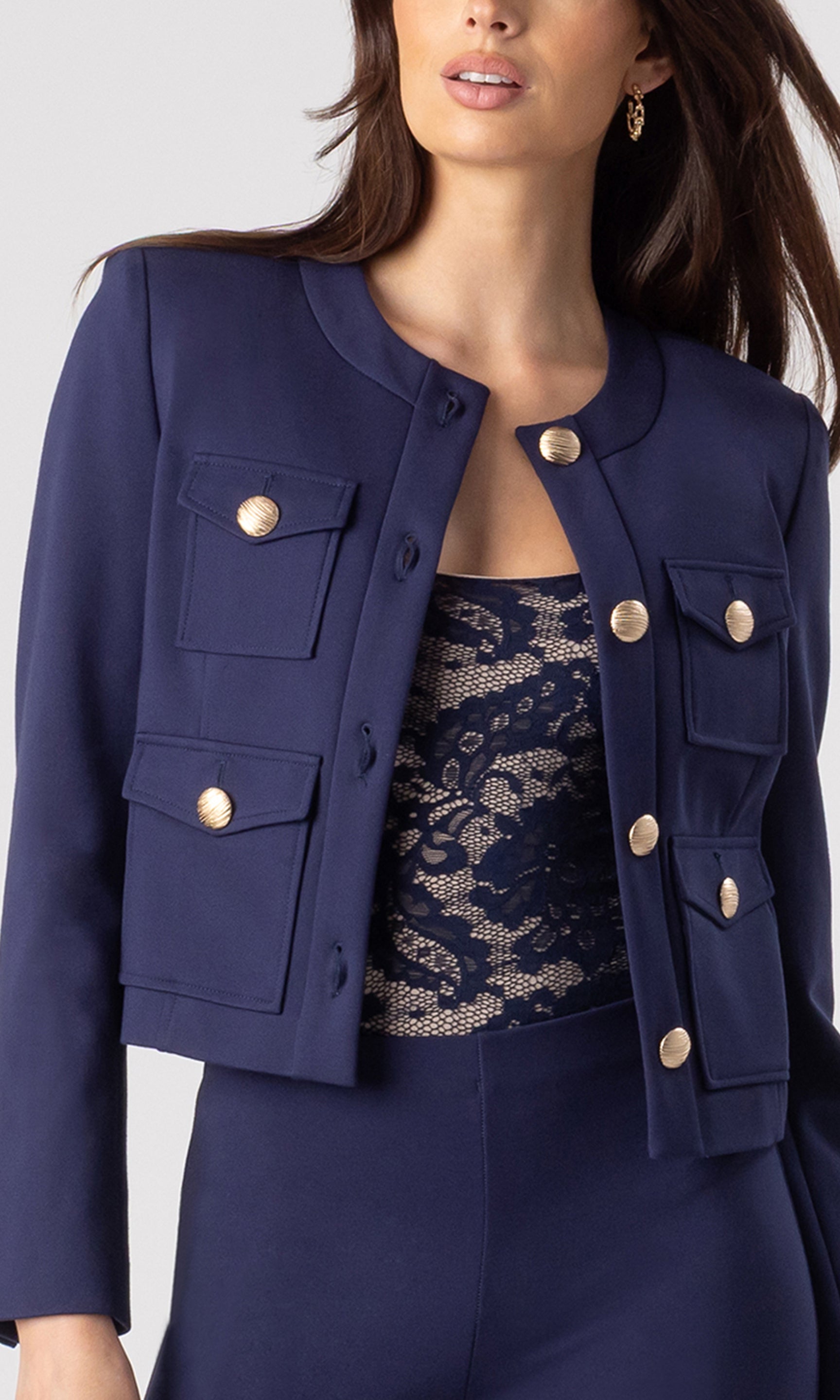zoomed in image of model wearing the Siena Ponte Jacket in navy showcasing the beautiful structure of the jacket with the accent buttons on the front, over a navy/beige tank bodysuit and paired with navy leggings