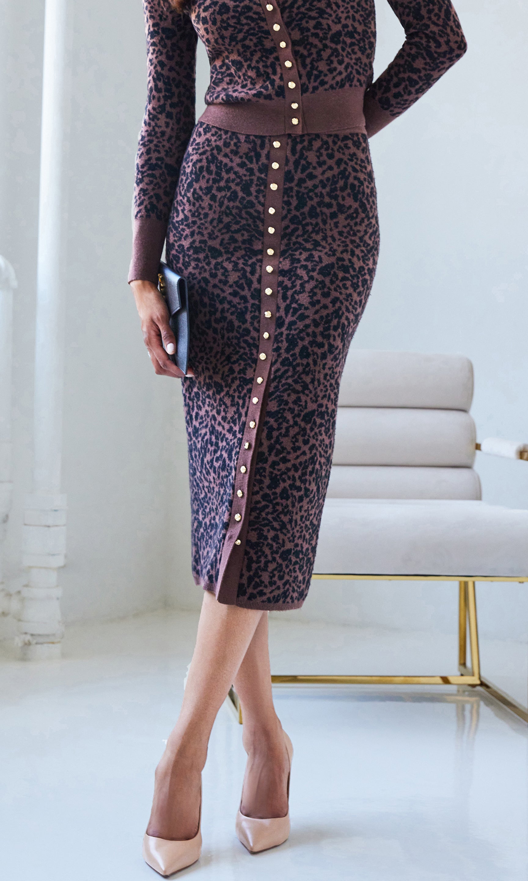 Woman wearing a leopard skirt with matching top in an indoor setting.