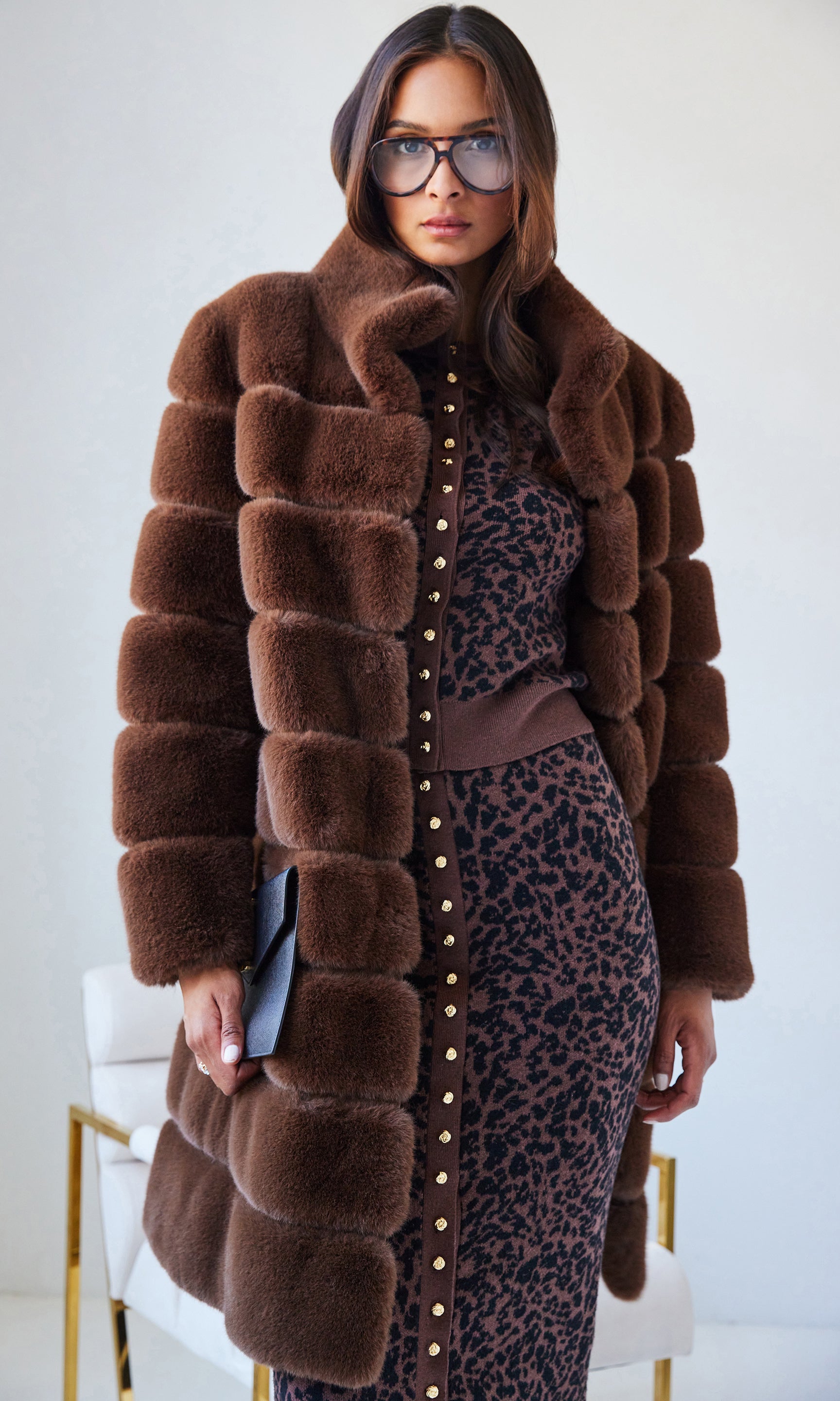 Woman wearing a brown fur coat with a white background