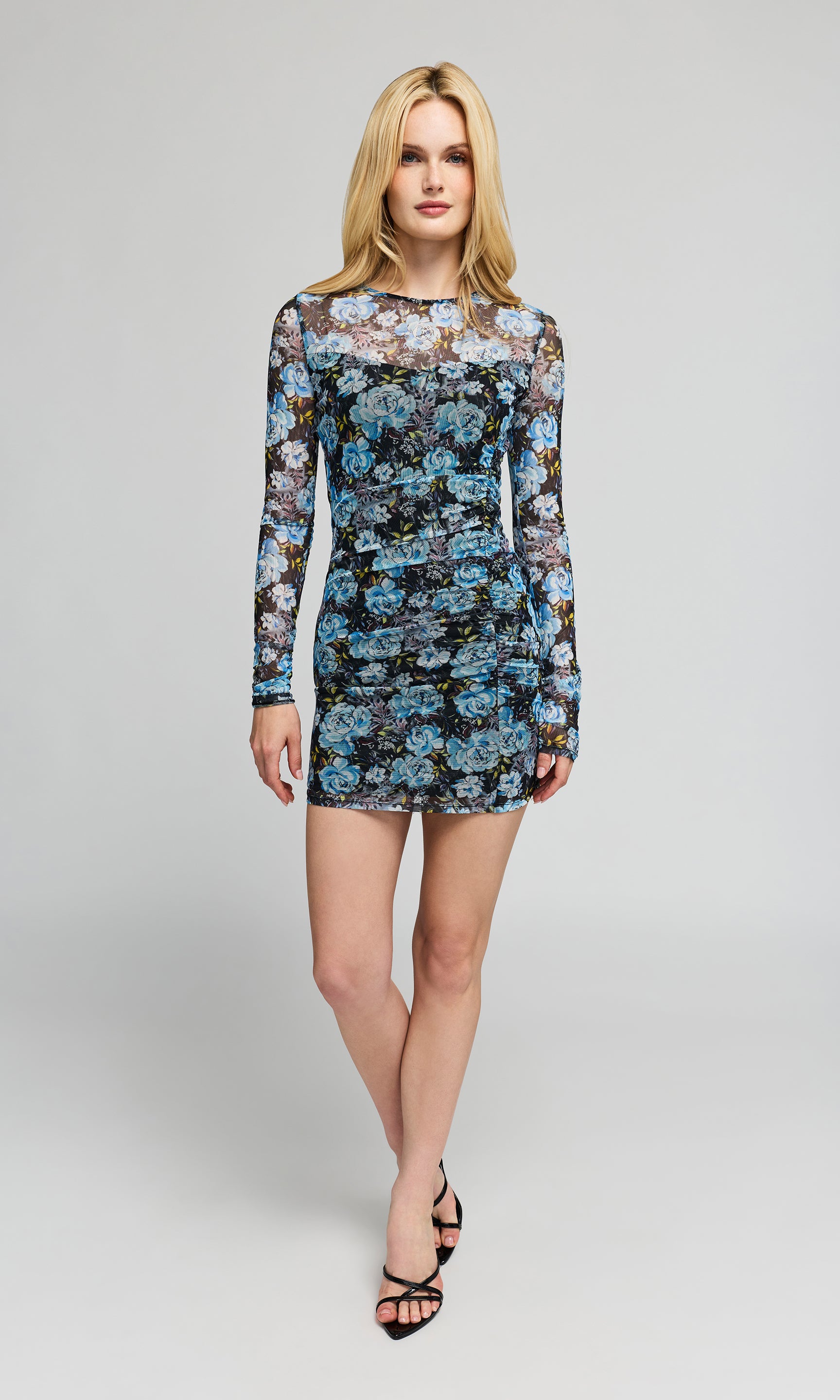 Woman wearing a floral mini dress on a gray background