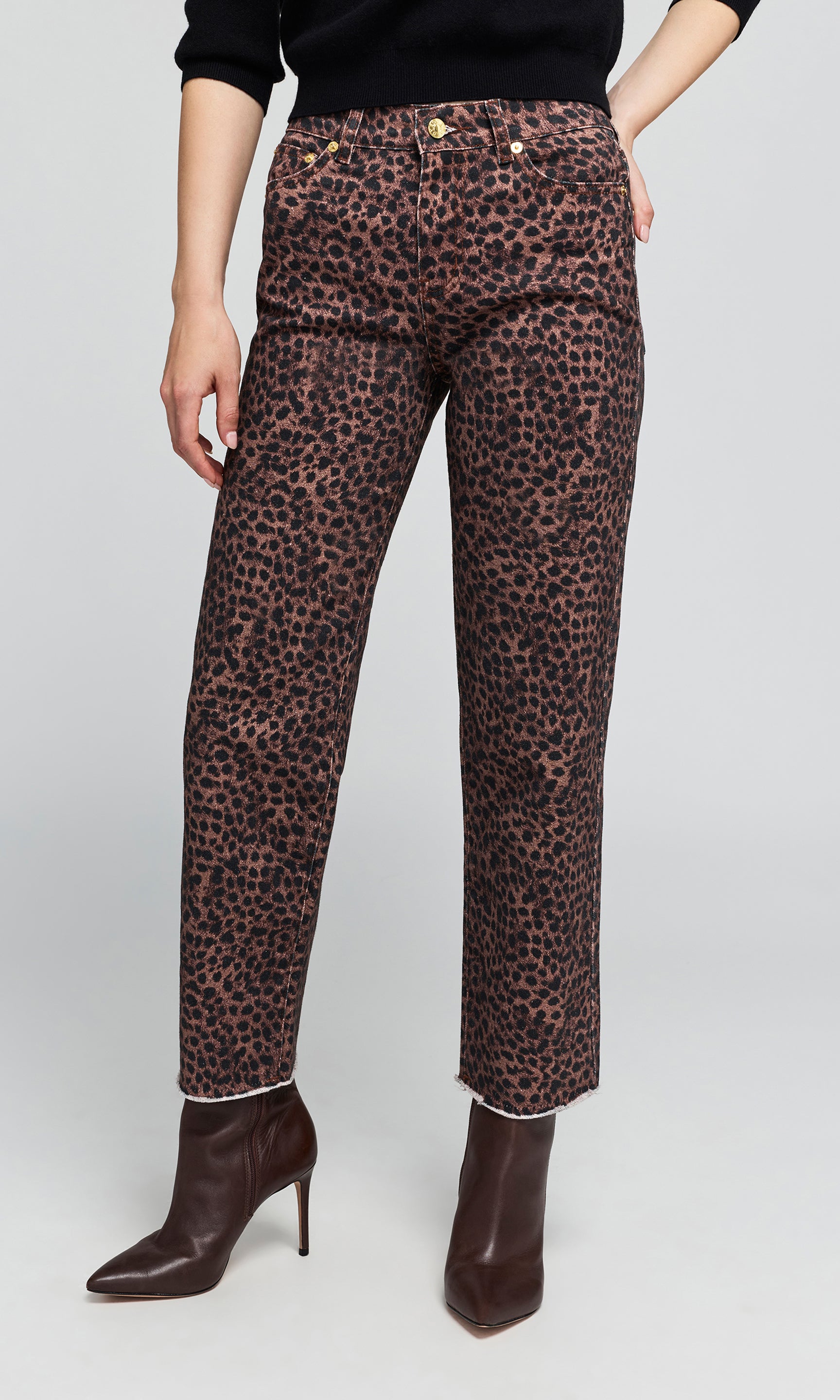 Model wearing high-waisted leopard-print trousers in brown and black, paired with dark brown pointed-toe ankle boots.