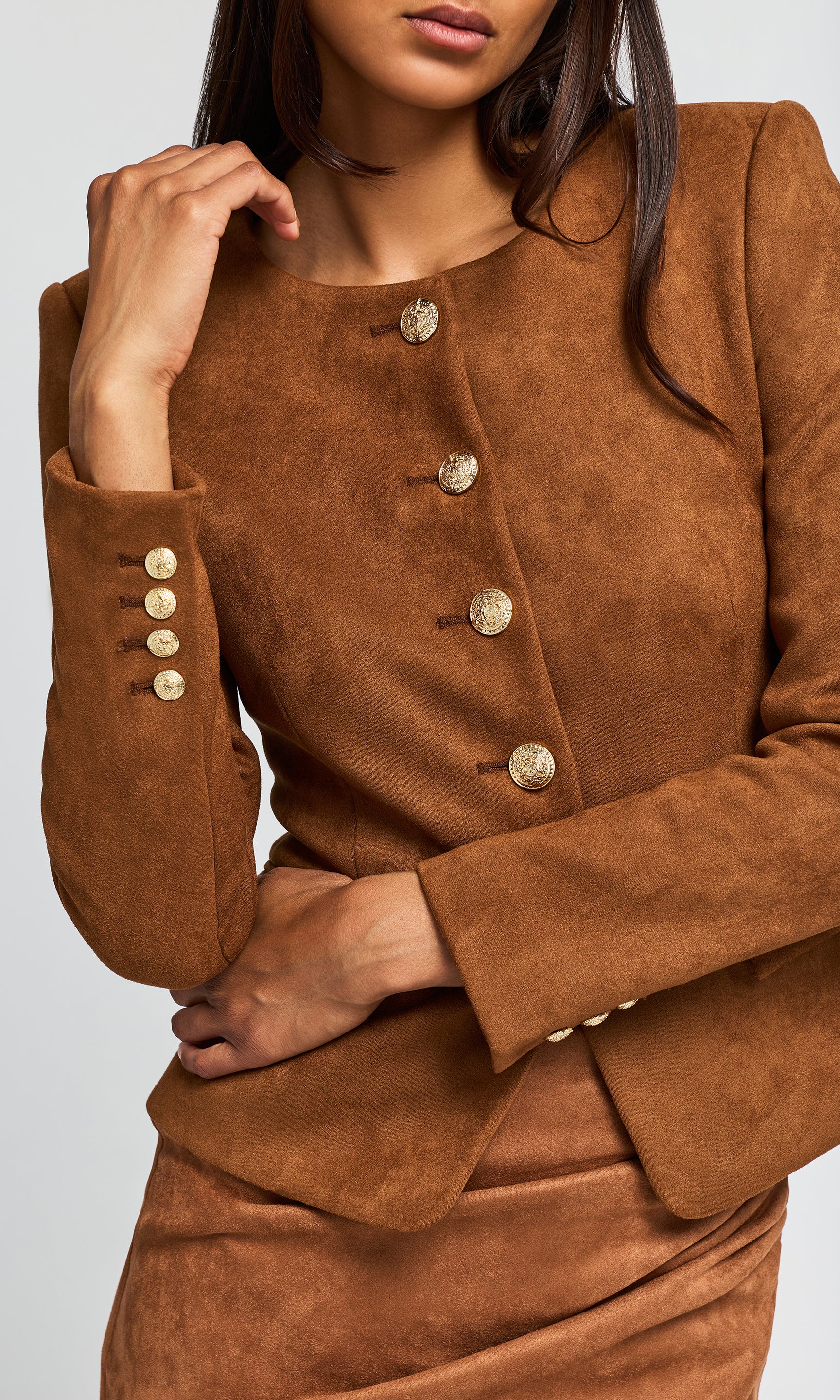 Close-up of a brown suede-like blazer with gold-tone buttons down the front and matching buttoned cuffs.
