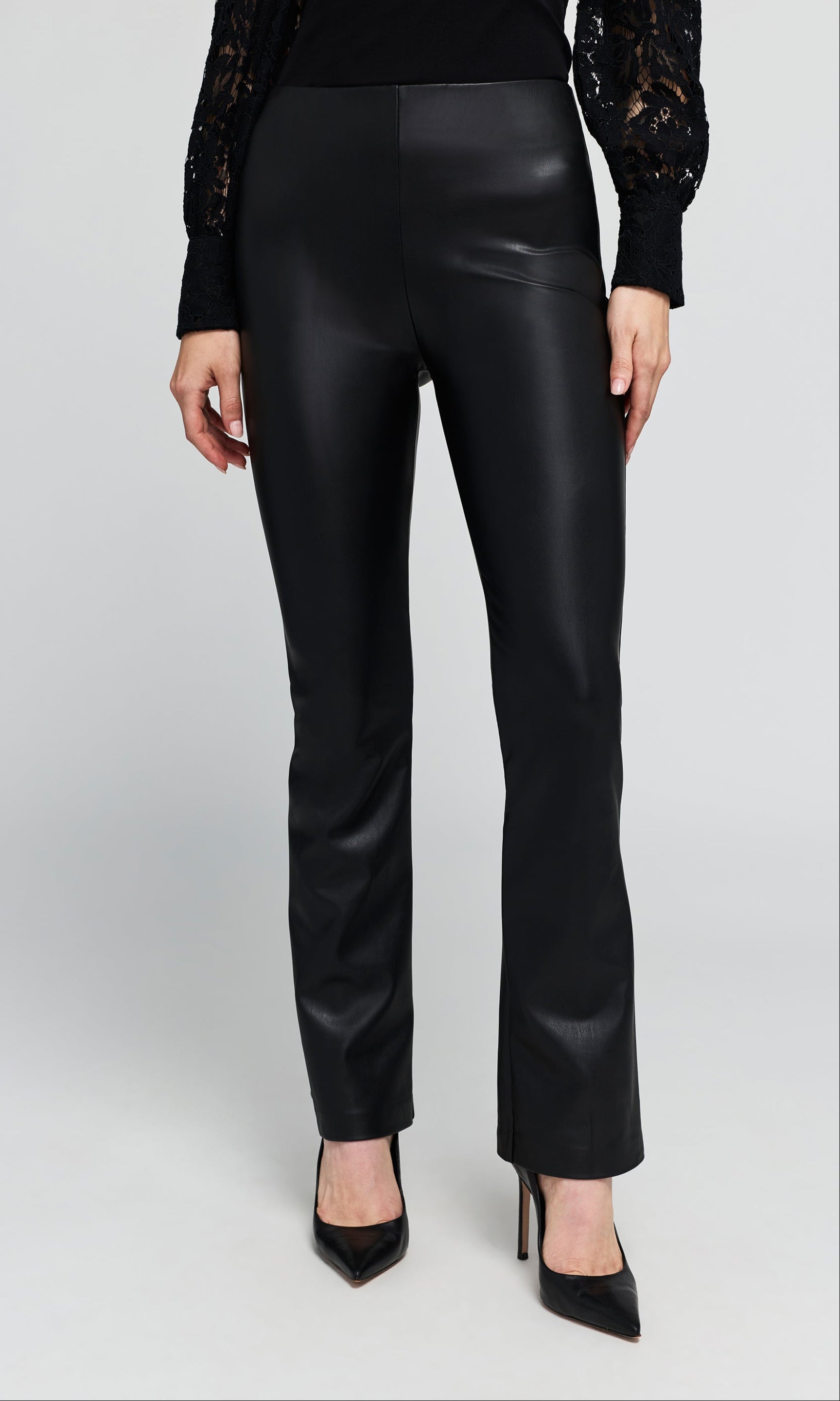 Model wearing a black faux-leather straight-leg pants paired with a black lace long-sleeve top.